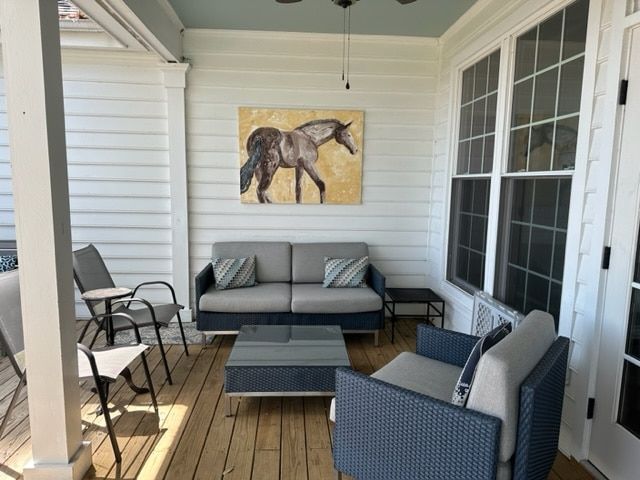 A porch with a couch and chairs and a painting of a horse on the wall