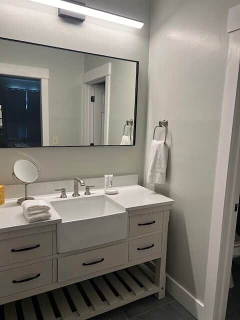 A bathroom with a sink , mirror and drawers