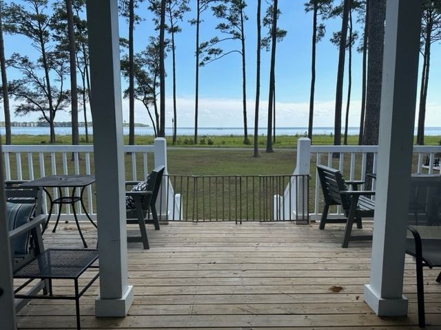 A deck with a view of the ocean and trees