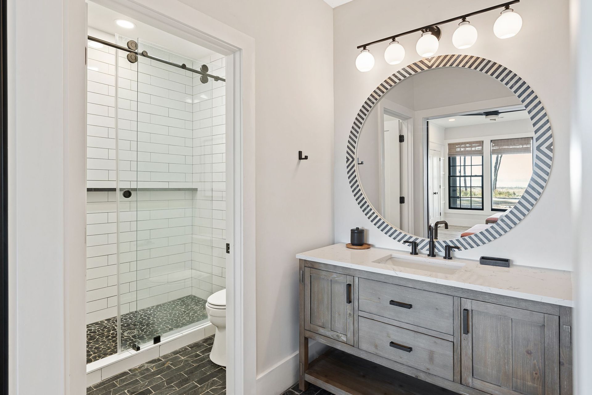 A bathroom with a sink , mirror and shower.