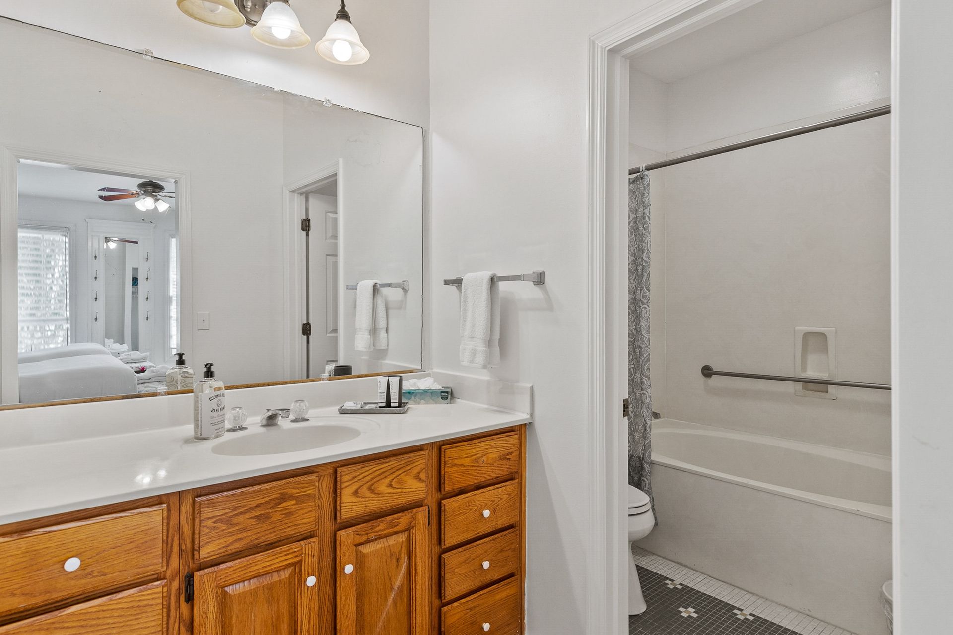 A bathroom with a sink , mirror , toilet and bathtub.
