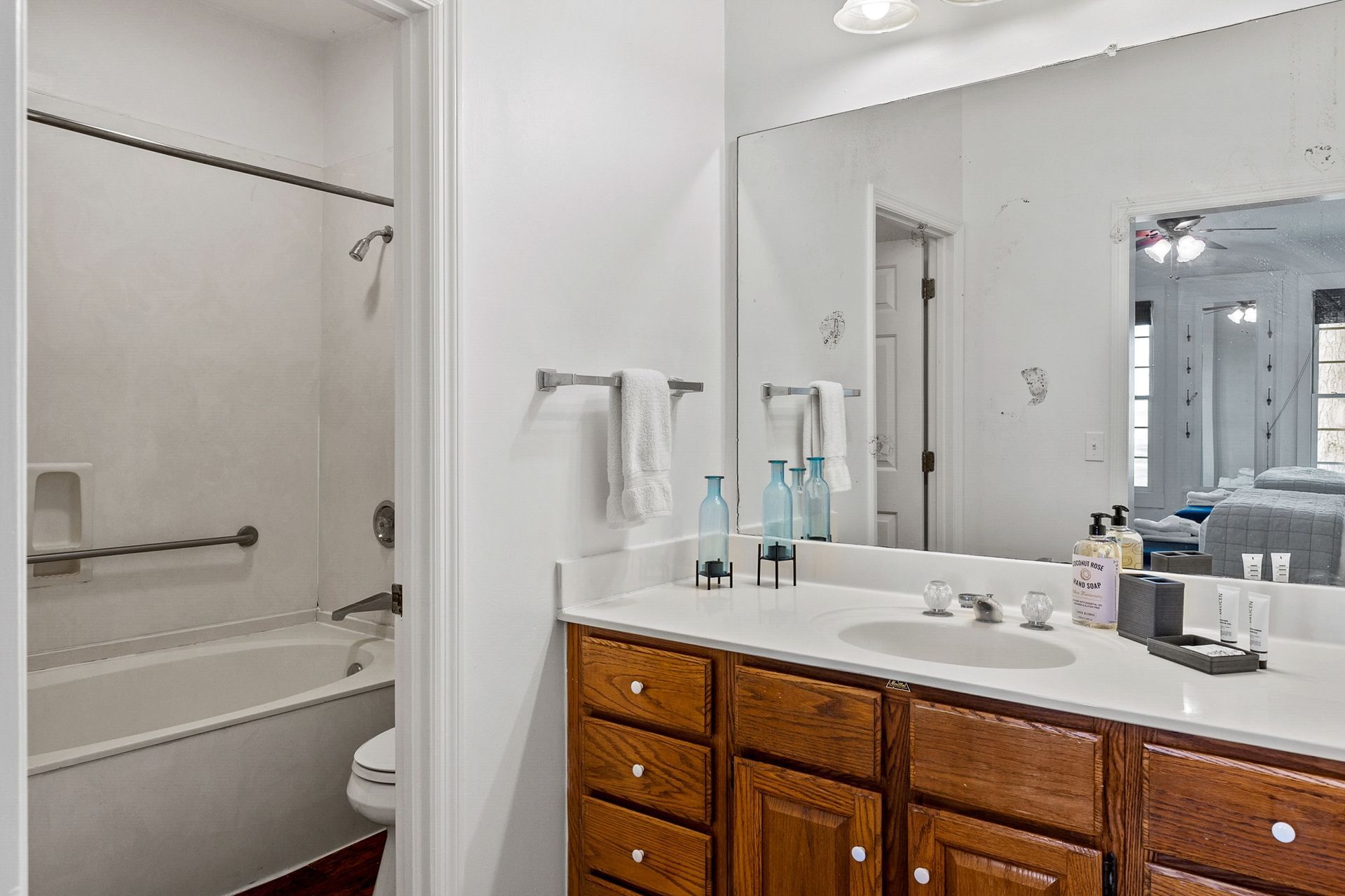 A bathroom with a sink , toilet , tub and mirror.