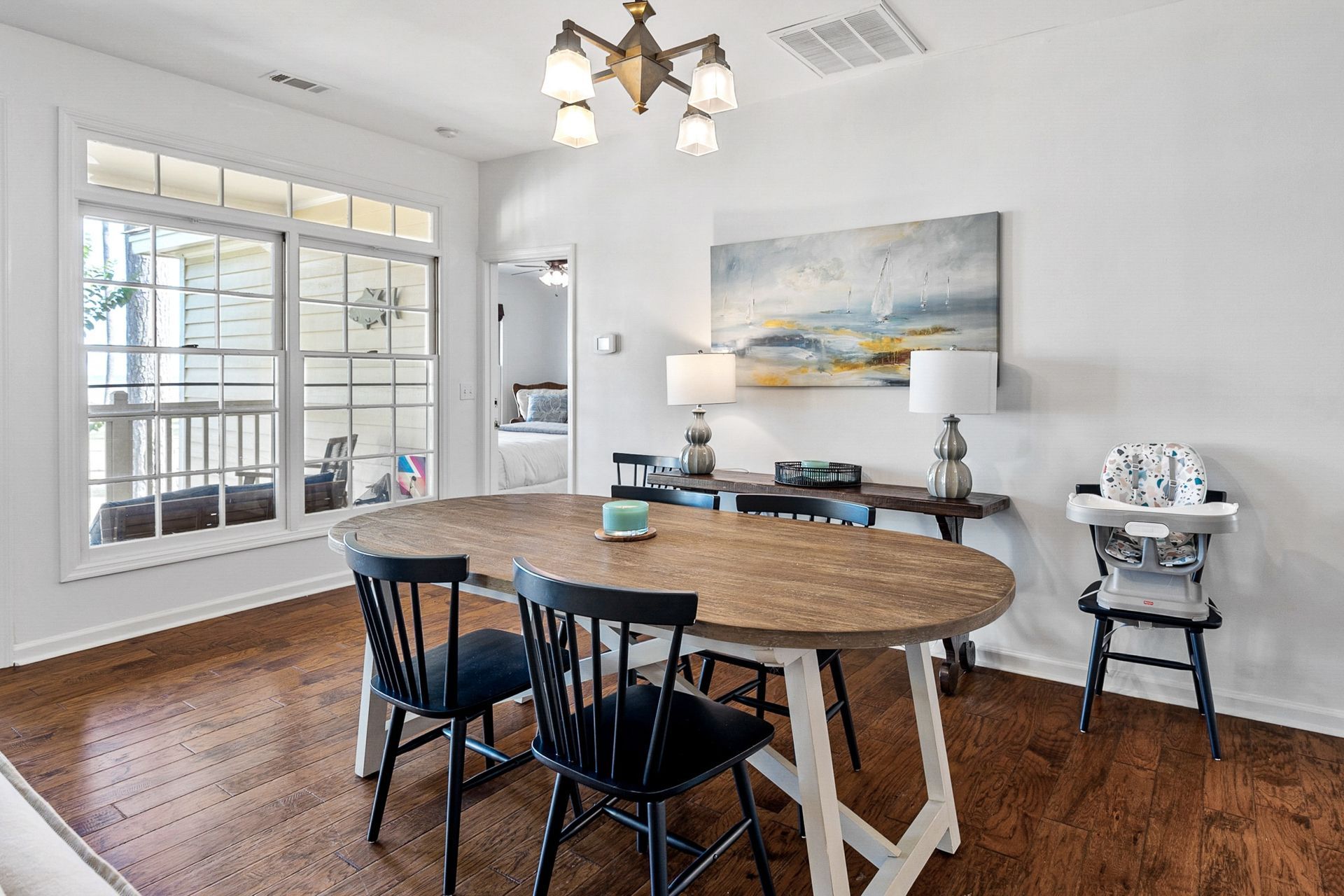 A dining room with a table and chairs and a high chair.