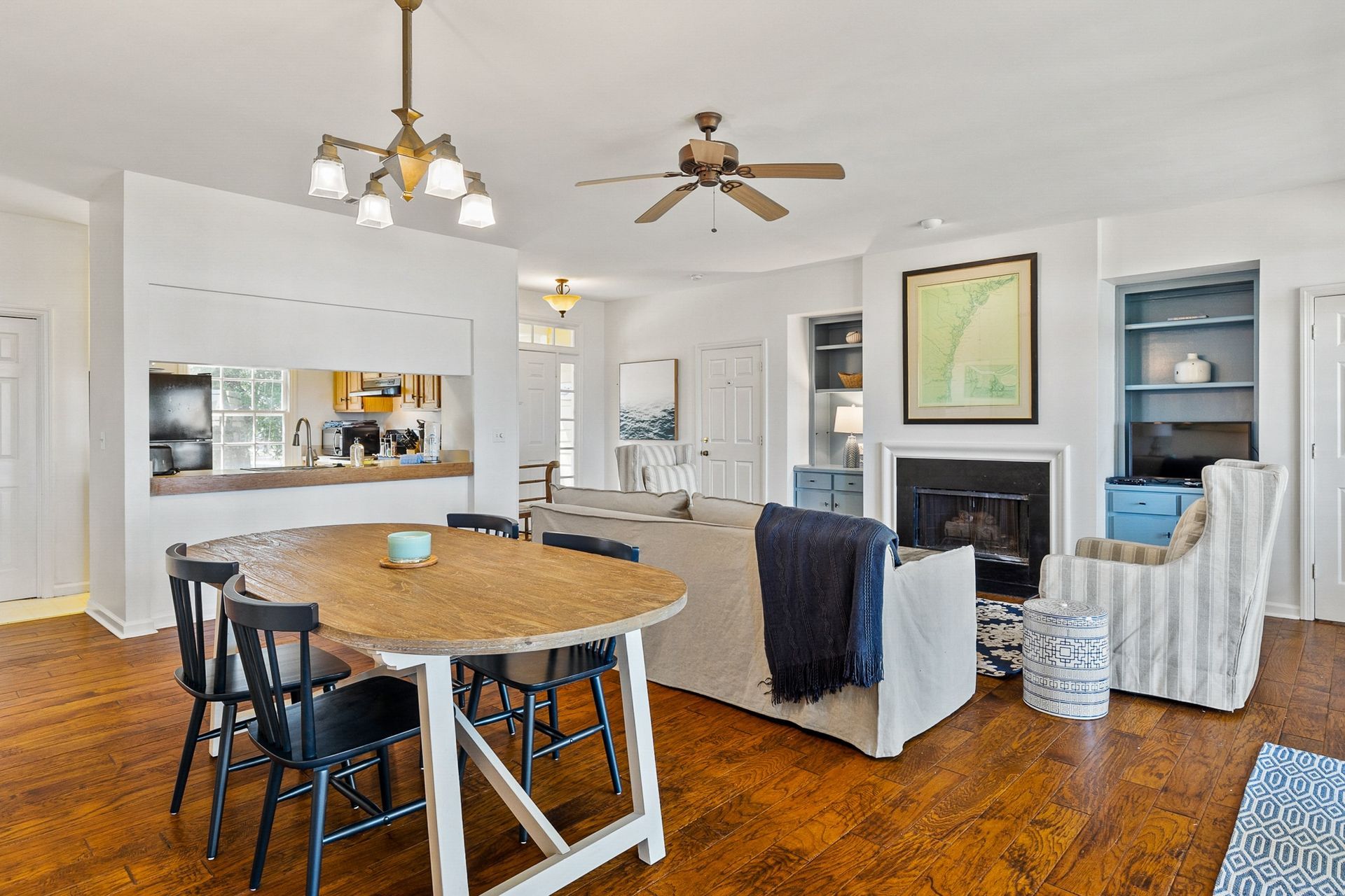 A living room with a table and chairs and a ceiling fan.