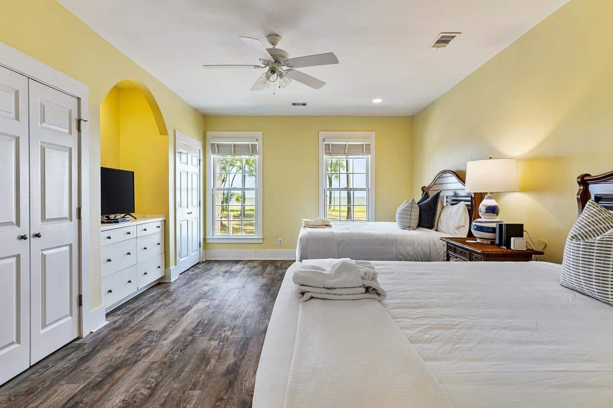 A bedroom with two beds and a ceiling fan.