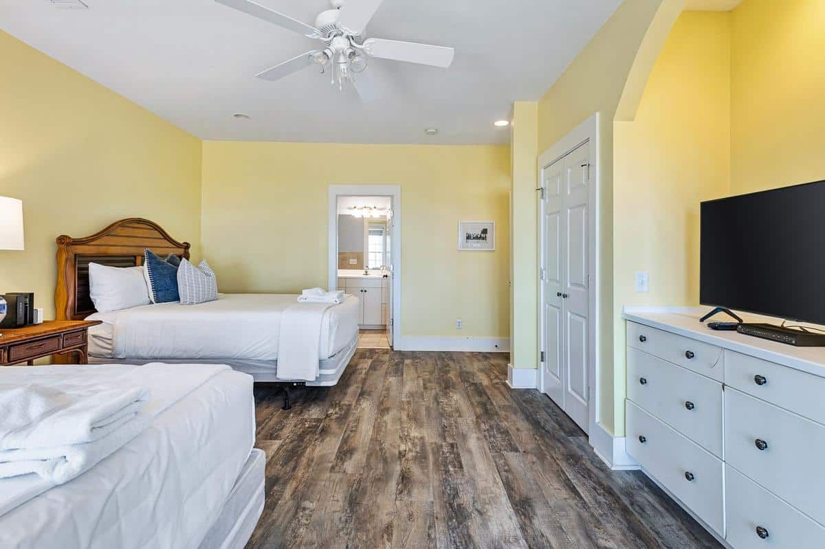 A bedroom with two beds and a flat screen tv.