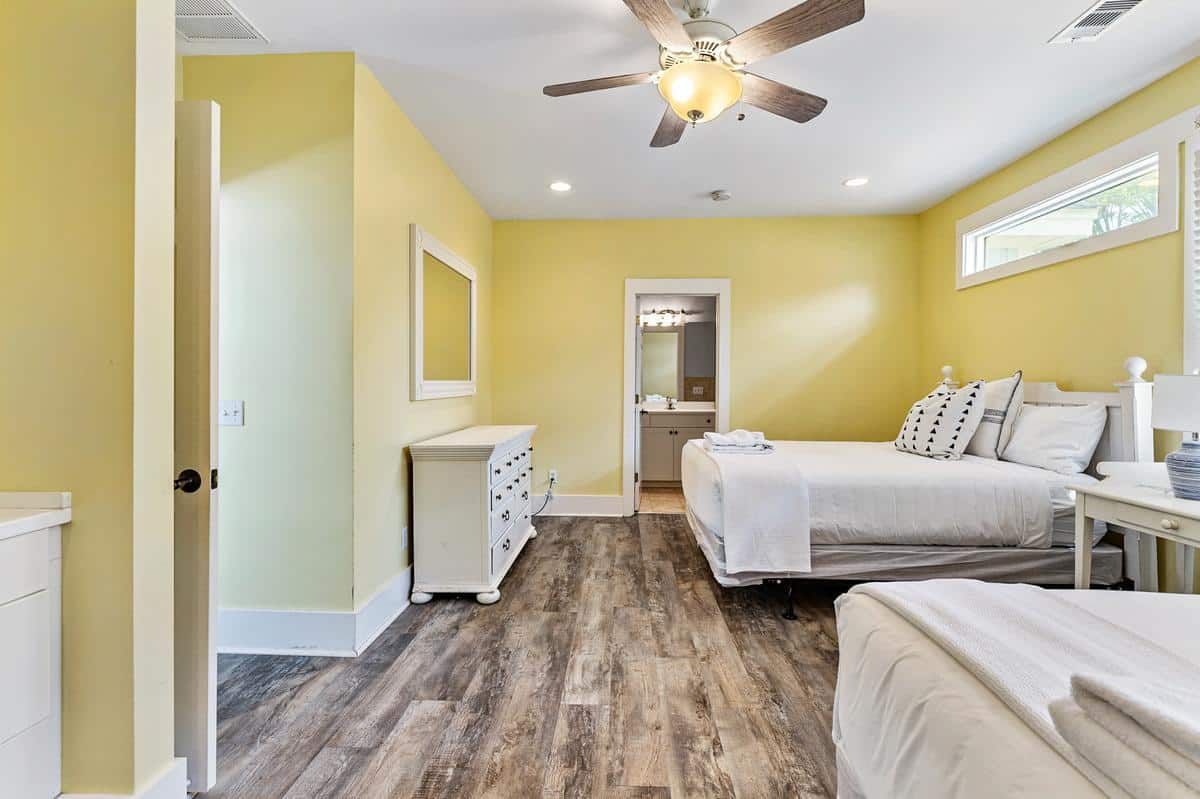 A bedroom with two beds and a ceiling fan.
