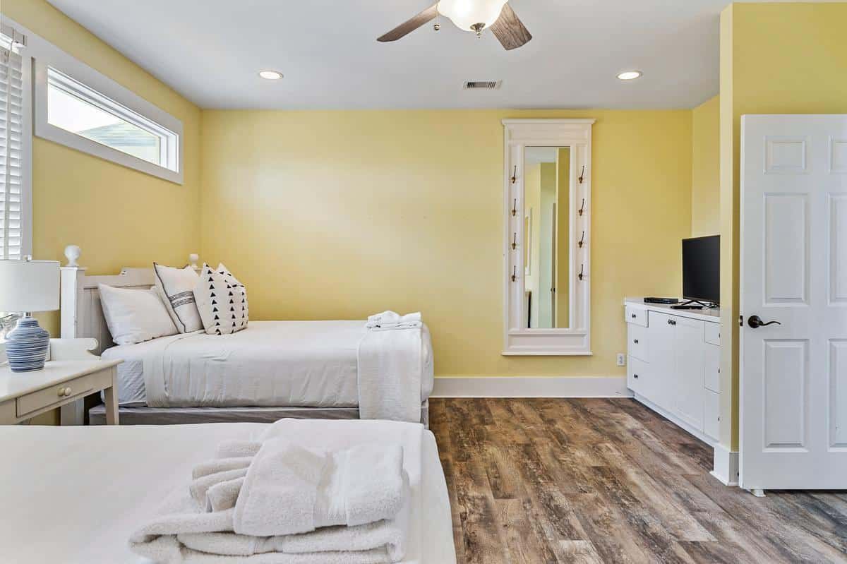 A bedroom with two beds and a ceiling fan.