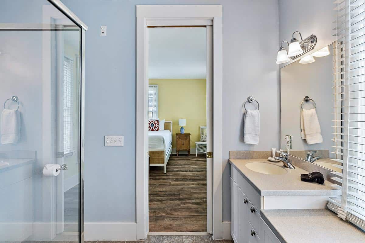 A bathroom with a sink , mirror , and walk in shower.