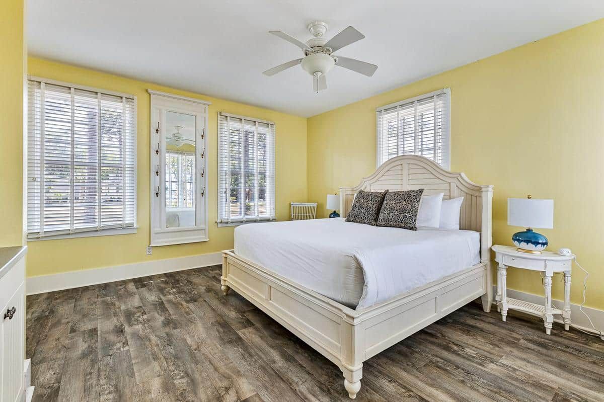 A bedroom with a king size bed and a ceiling fan.