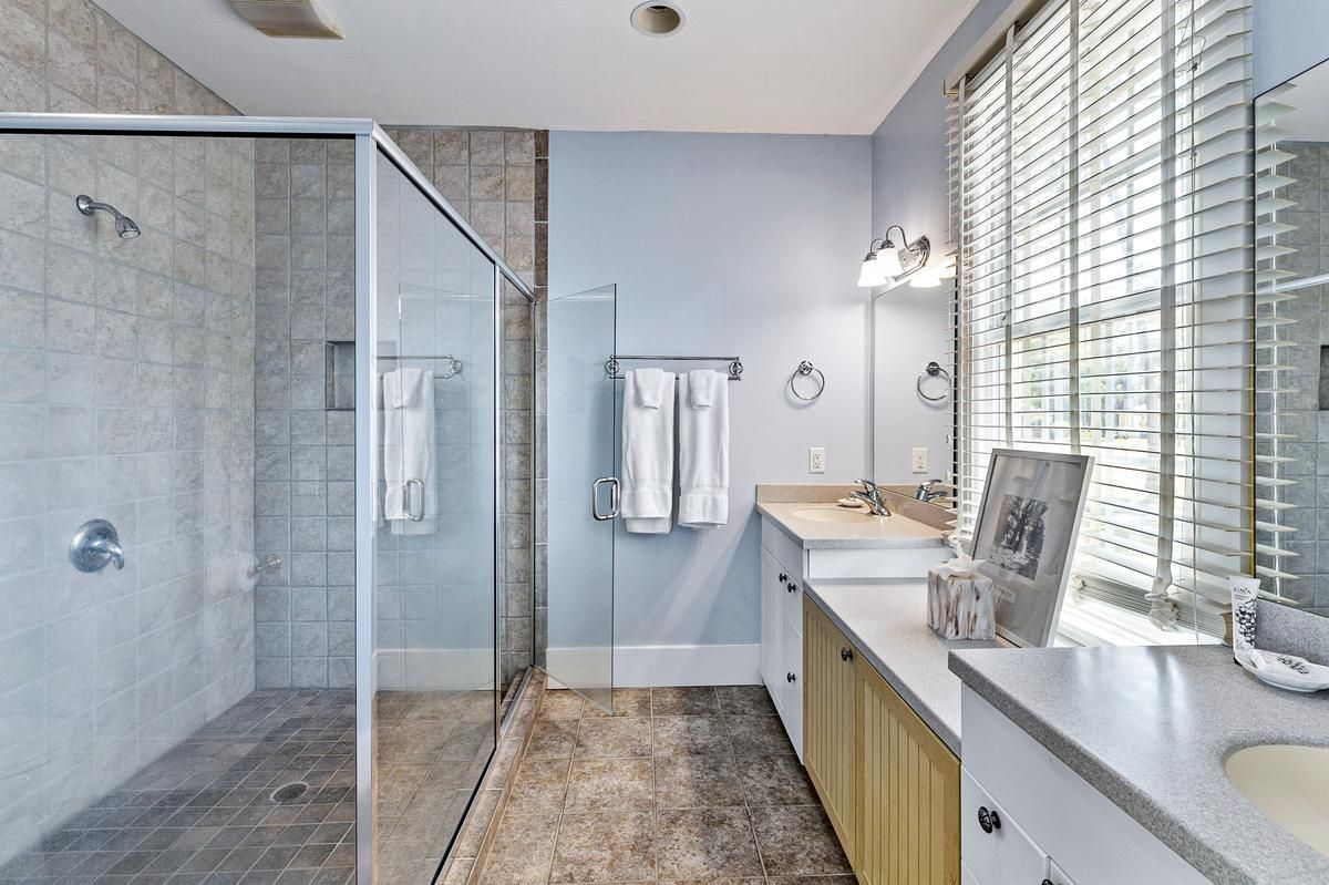 A bathroom with a walk in shower , sink , and mirror.