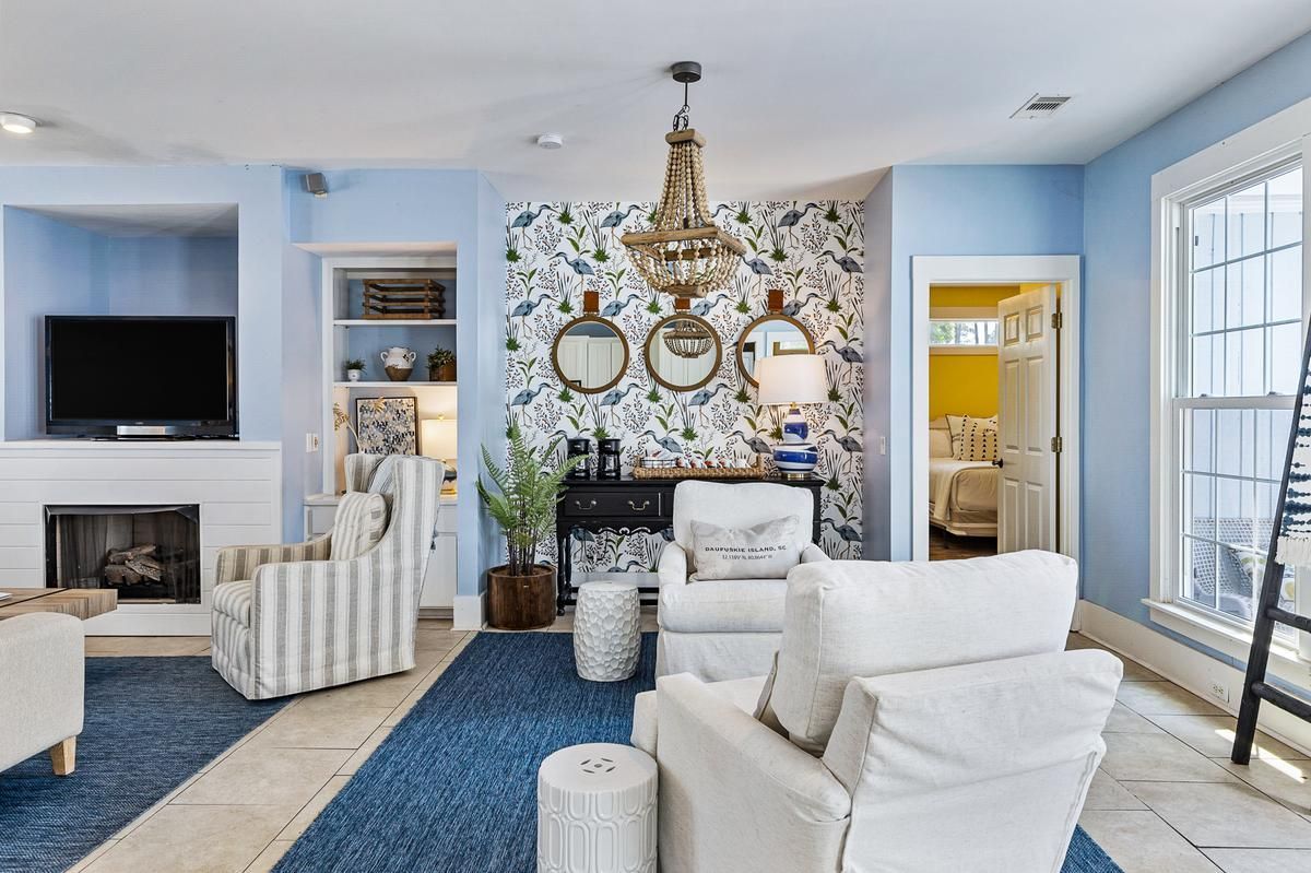 A living room with blue walls and white furniture