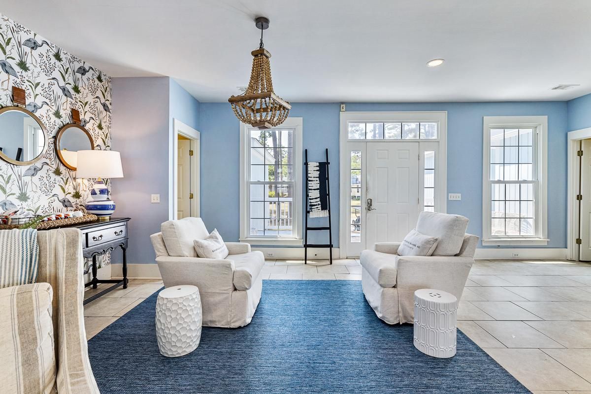 A living room with blue walls and white furniture