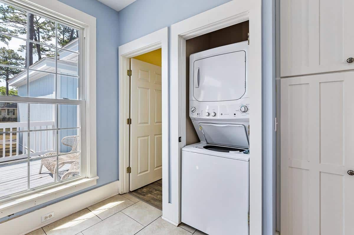 A washer and dryer are stacked on top of each other in a laundry room.