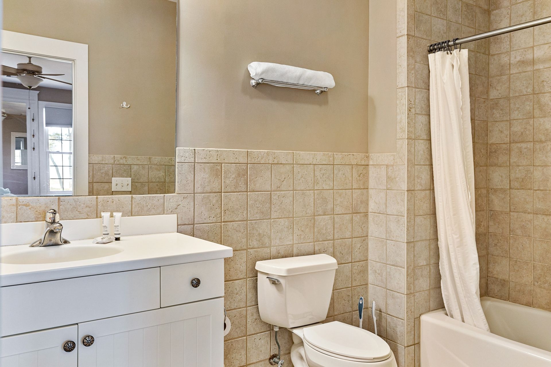 A bathroom with a toilet , sink and bathtub.