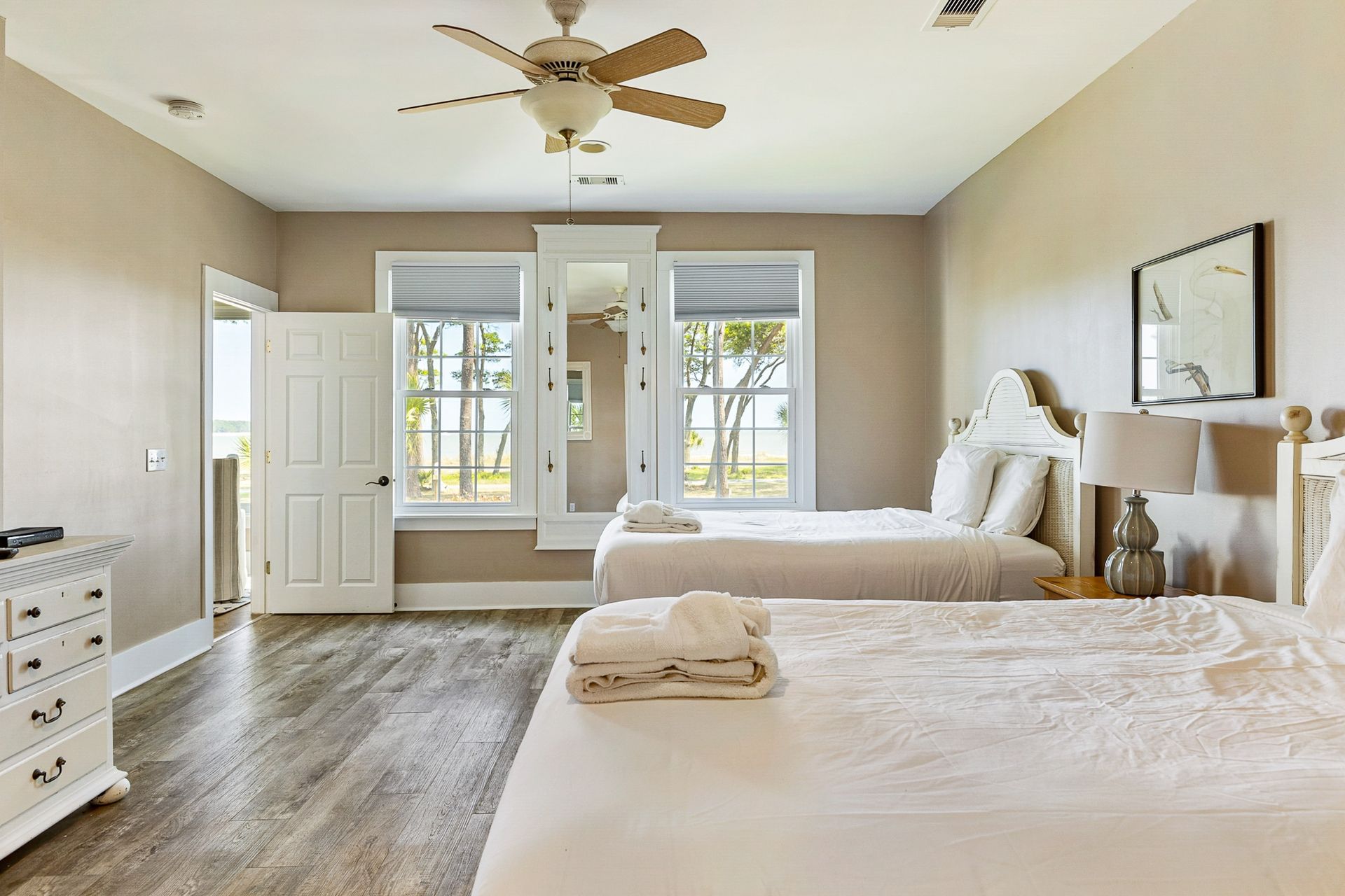 A bedroom with two beds and a ceiling fan.