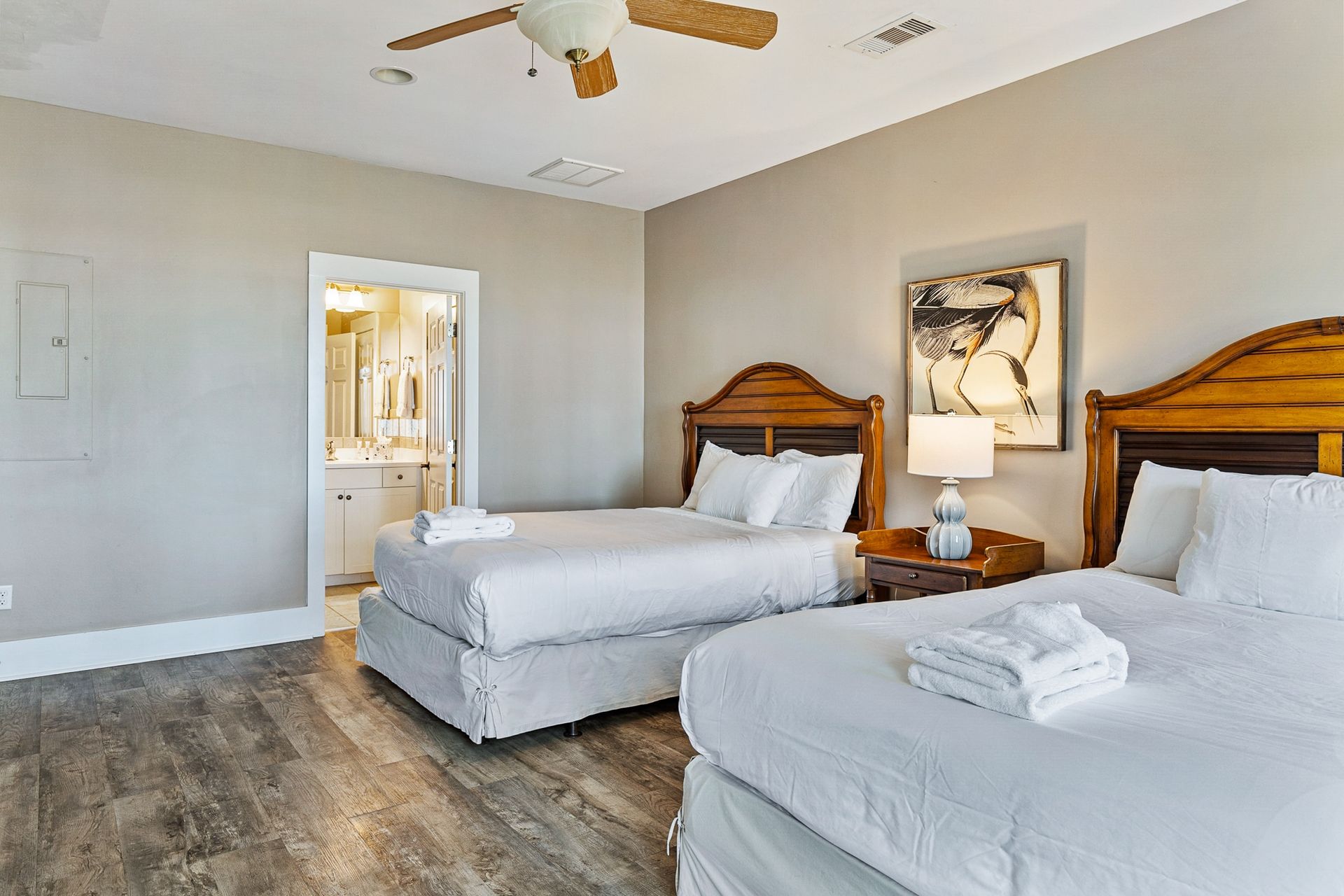 A hotel room with two beds and a ceiling fan.