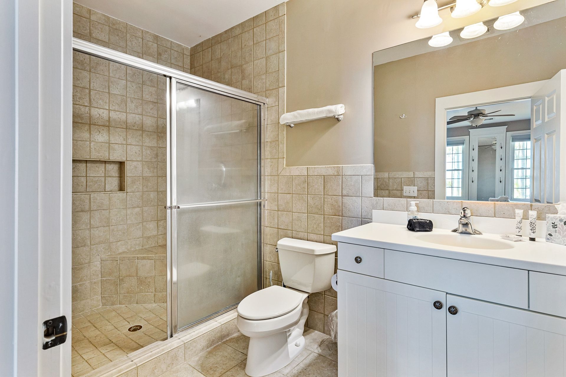 A bathroom with a toilet , sink and shower.