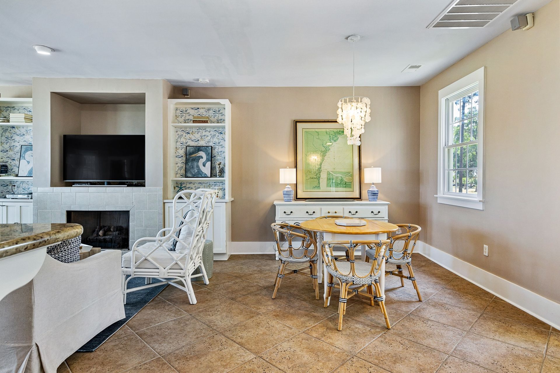 A living room with a table and chairs and a television.