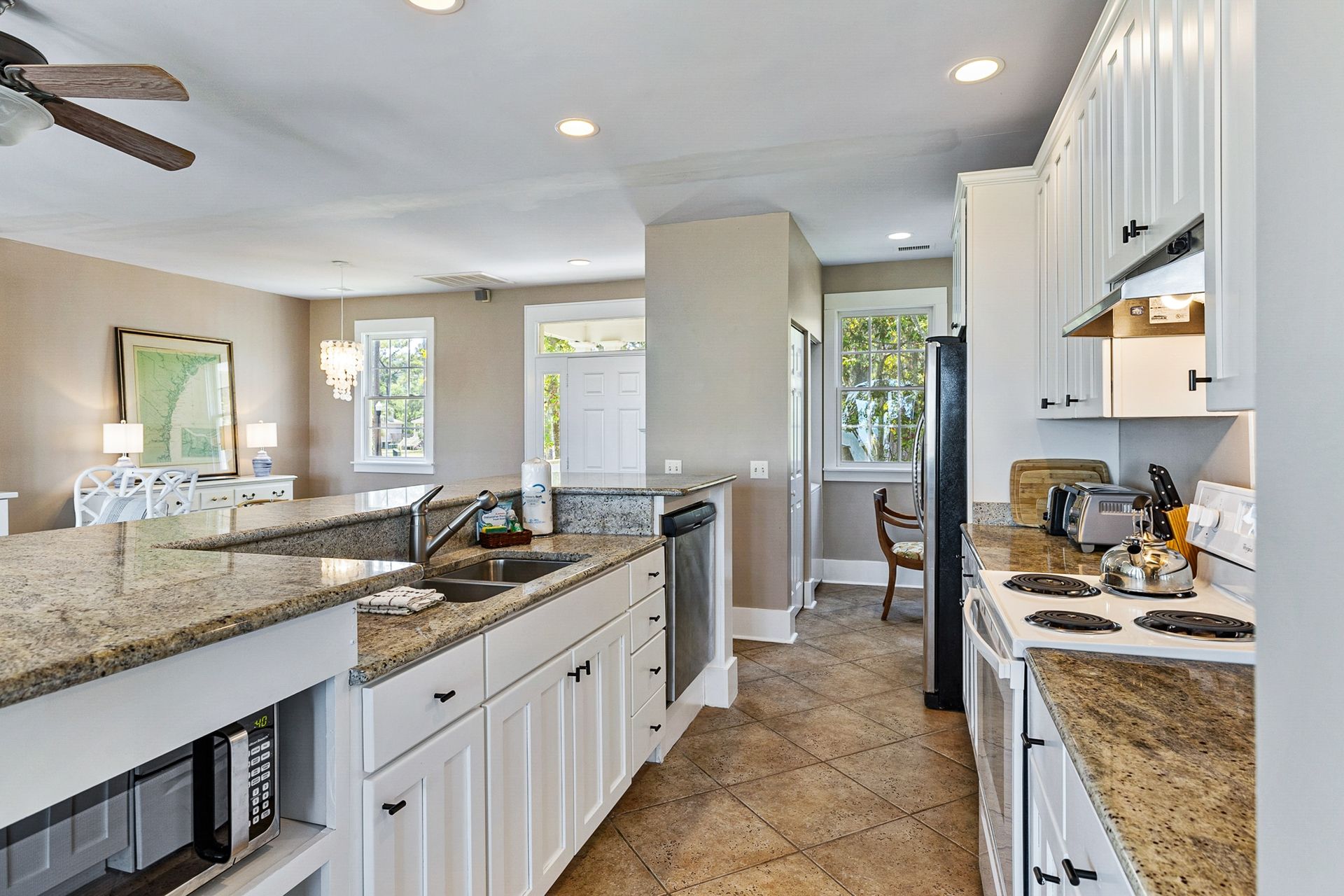 A kitchen with granite counter tops and white cabinets