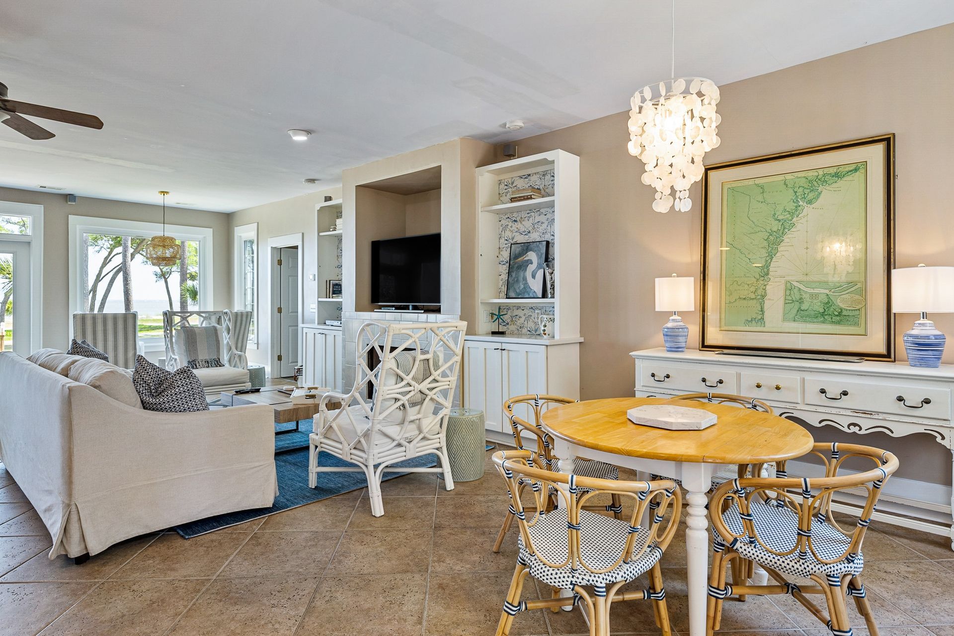 A living room with a table and chairs , a couch , and a television.