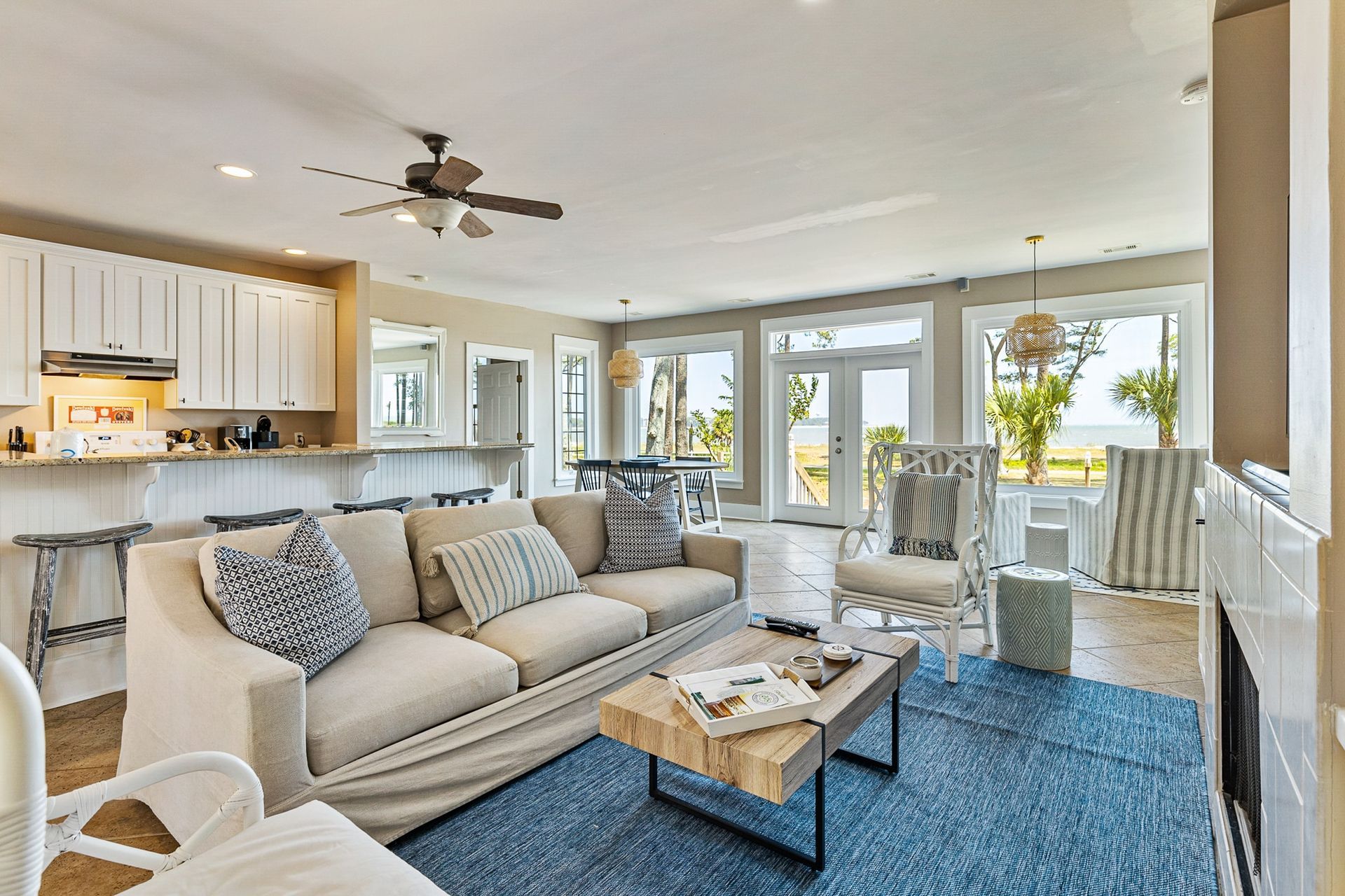 A living room with a couch , coffee table , chairs and a fireplace.