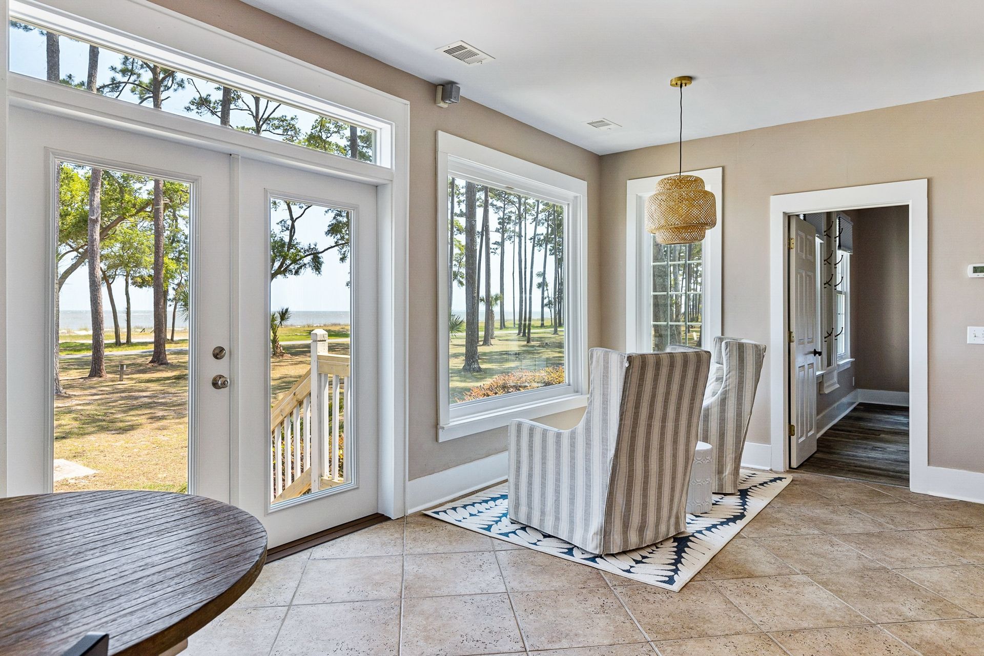 A dining room with a table and chairs and a view of the ocean.