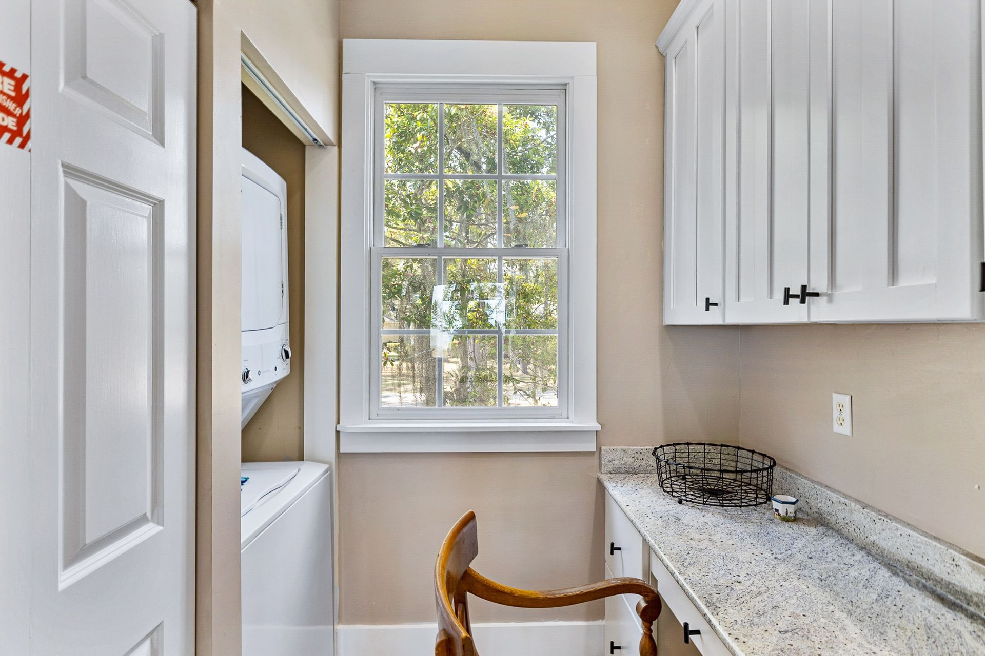 A laundry room with a washer and dryer and a window.
