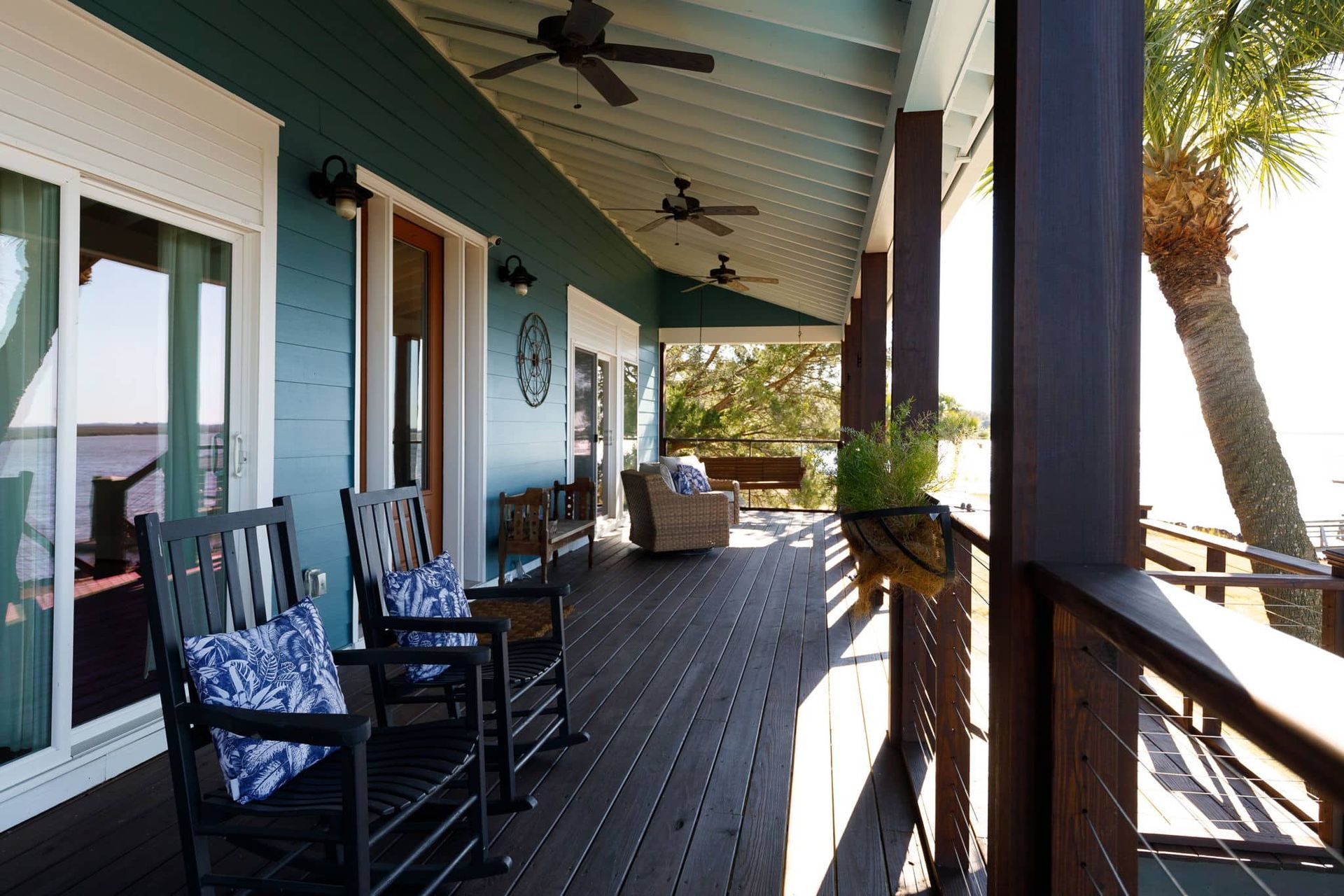 A porch with rocking chairs and a ceiling fan