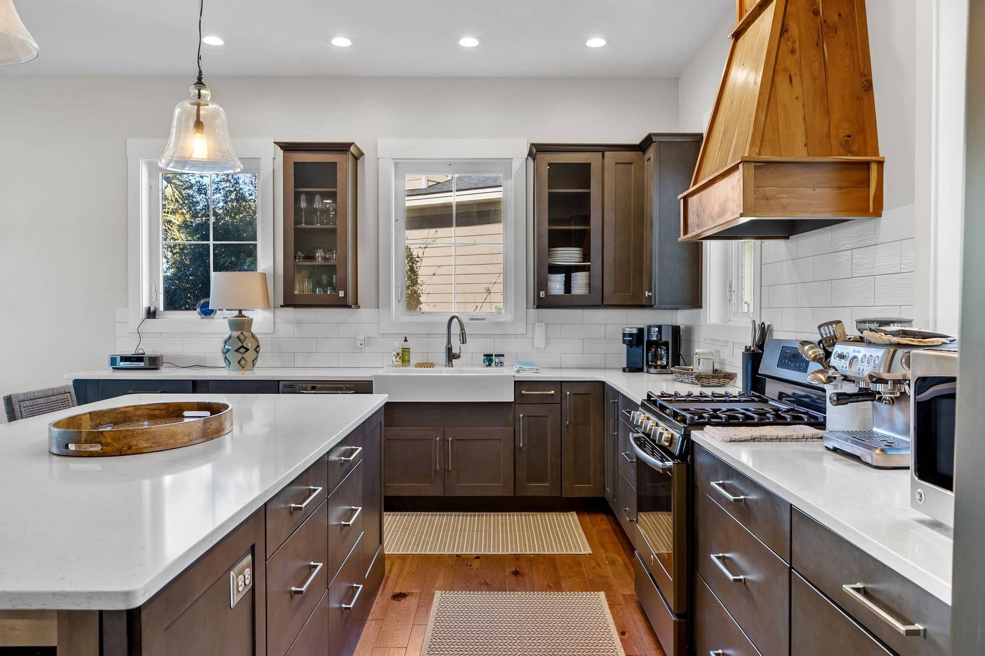 A kitchen with stainless steel appliances , wooden cabinets , and white counter tops.