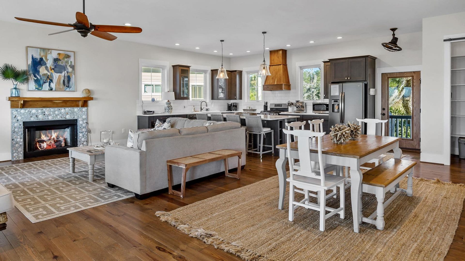 A living room with a couch , table , chairs and a fireplace.