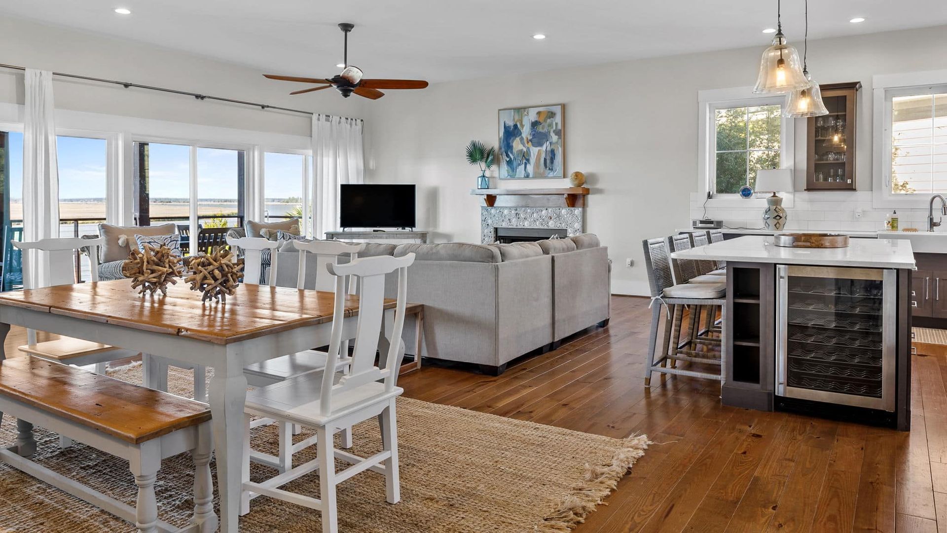 A living room with a dining table , chairs , and a ceiling fan.