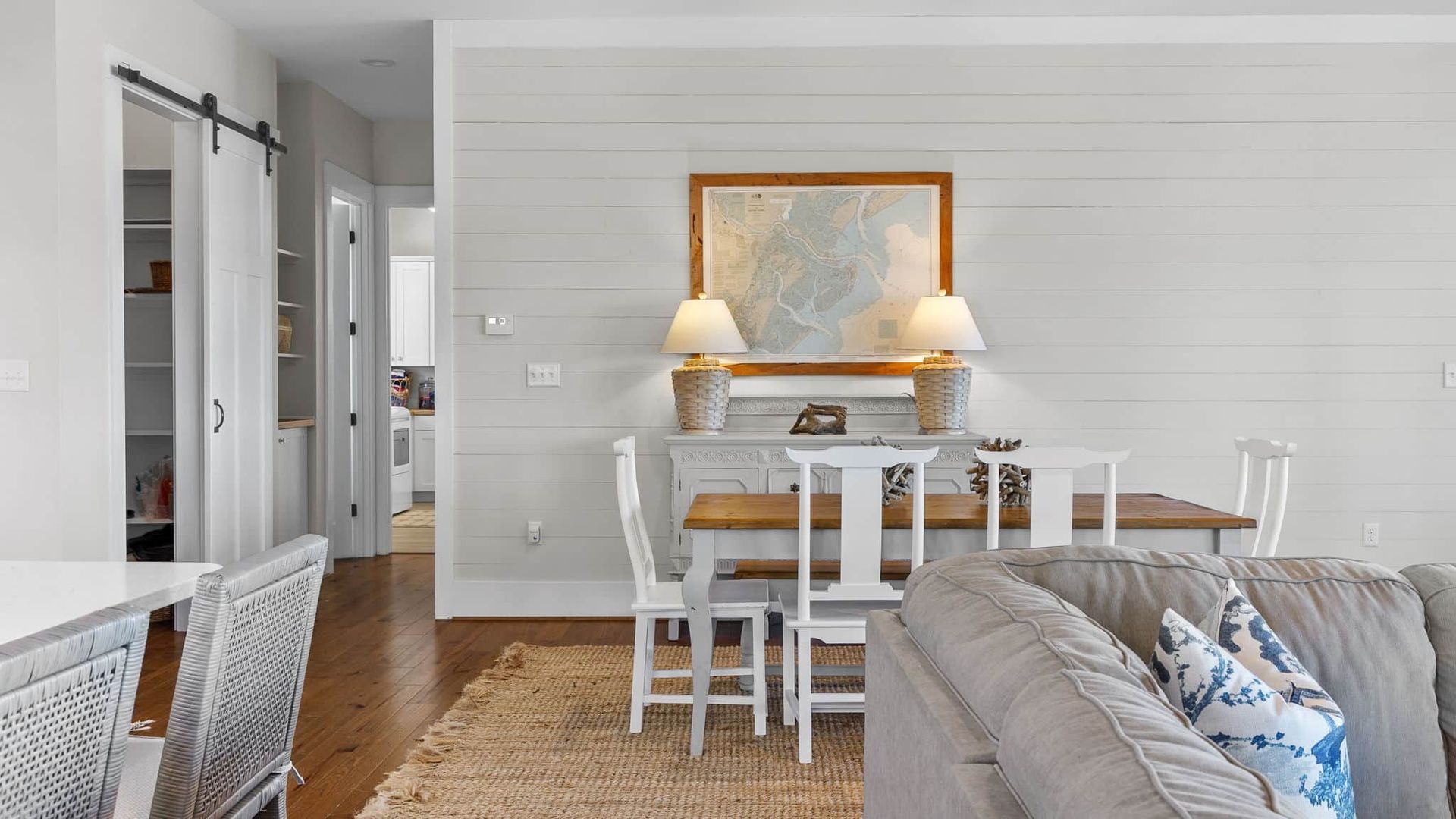 A living room with a couch , dining table and chairs.