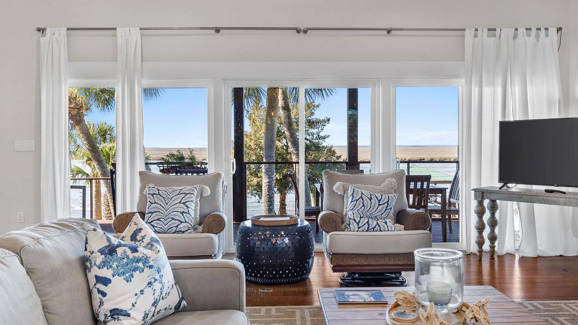 A living room with a couch , chairs , coffee table and television.