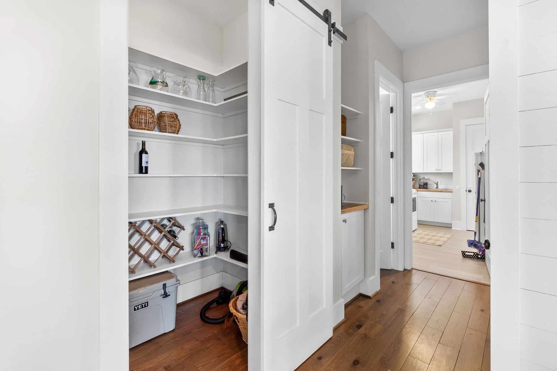 A pantry in a house with sliding barn doors and shelves.
