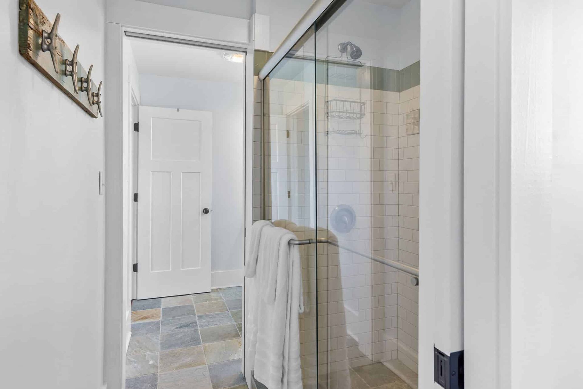 A bathroom with a walk in shower and a towel rack.