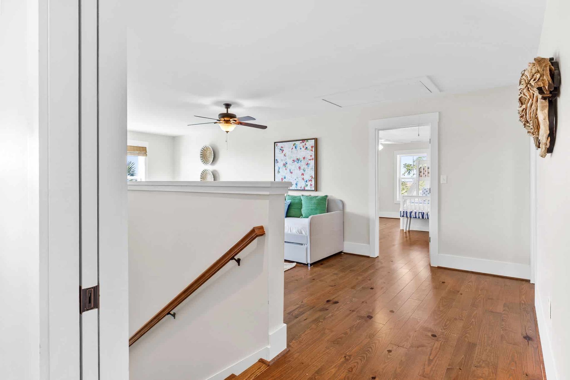 A hallway with hardwood floors and stairs leading up to the second floor of a house.