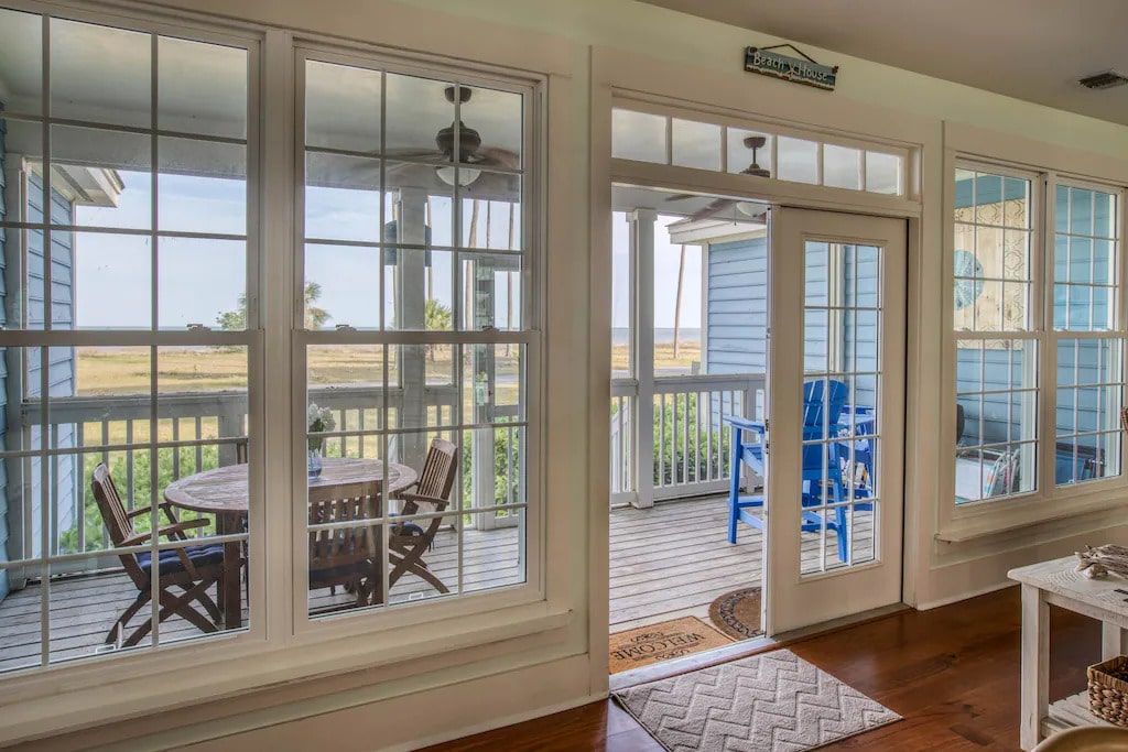A living room with a table and chairs on a porch.