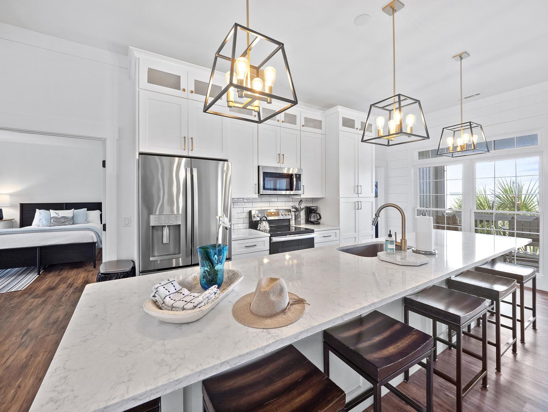A kitchen with white cabinets , stainless steel appliances and a large island.