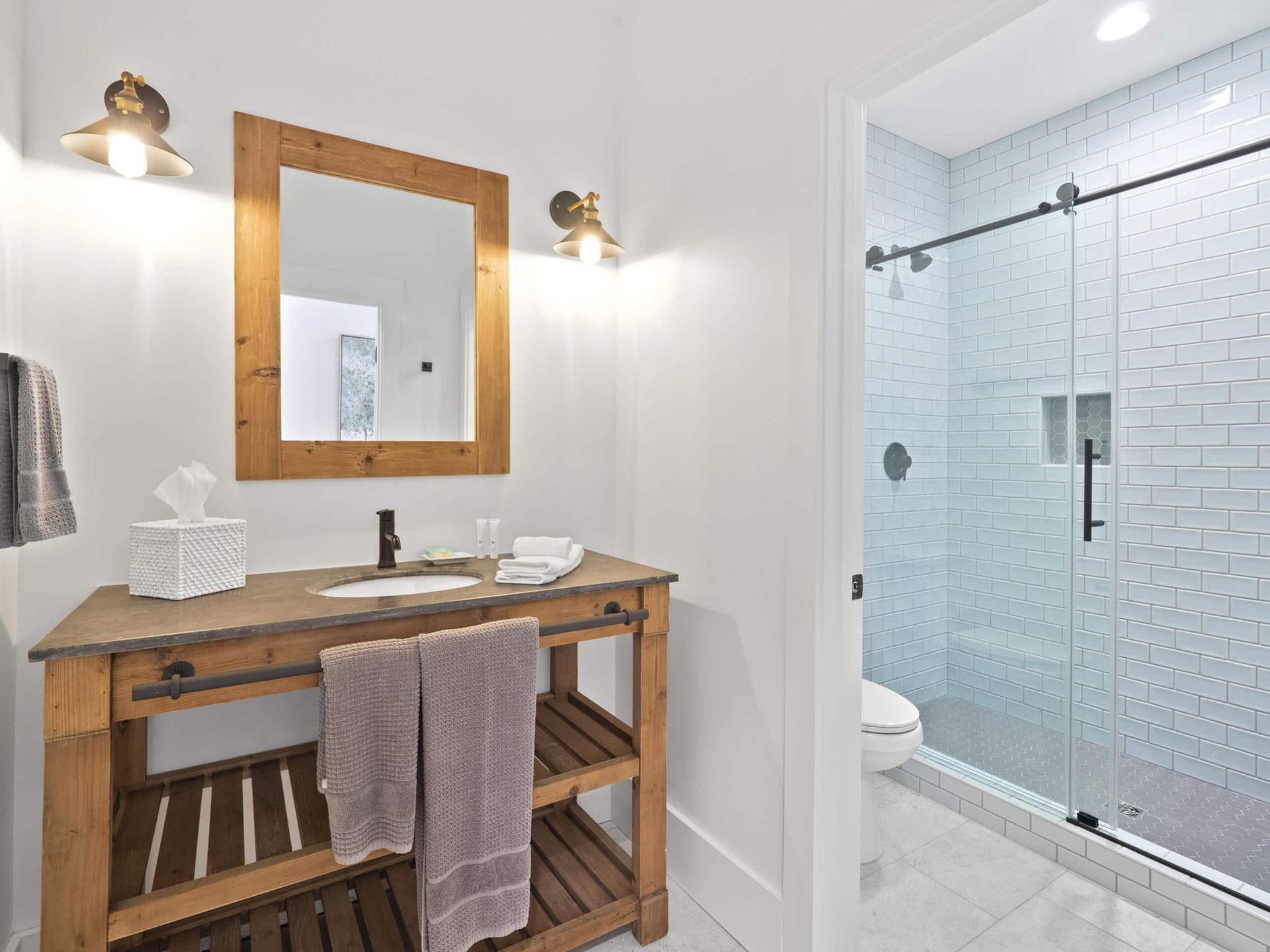 A bathroom with a wooden vanity and a mirror