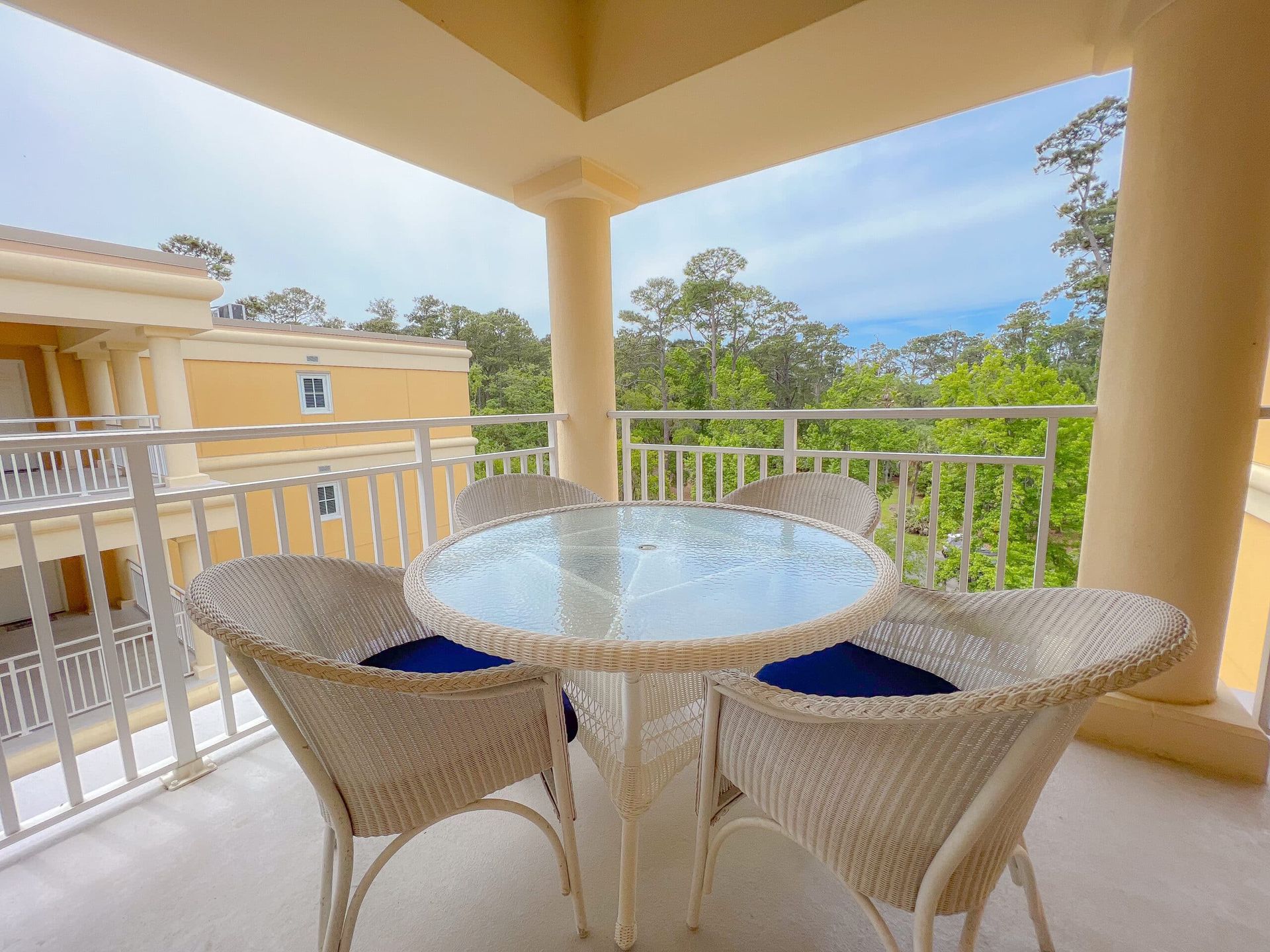 A balcony with a table and chairs with a view of the ocean