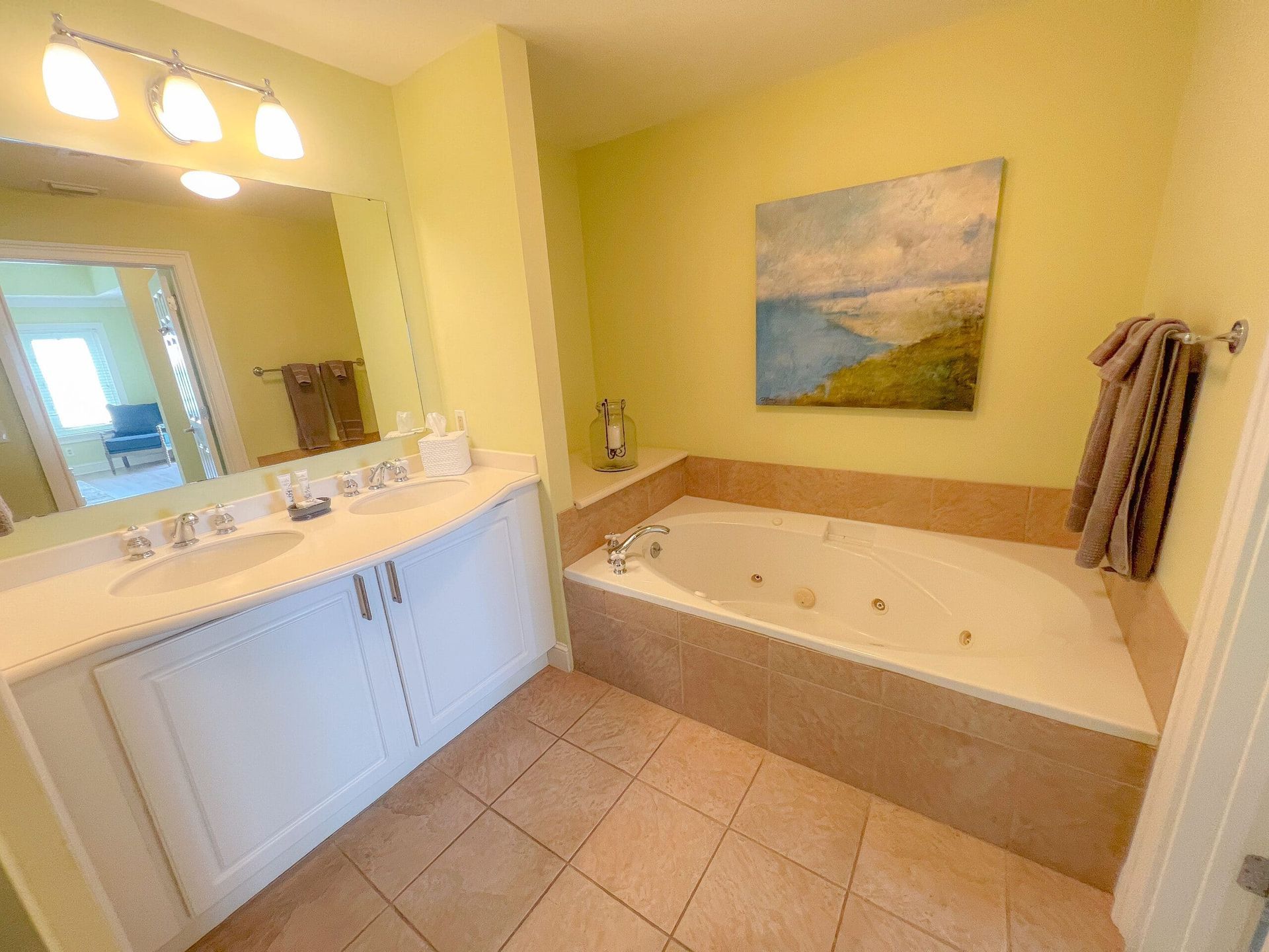 A bathroom with a jacuzzi tub , sink and mirror.