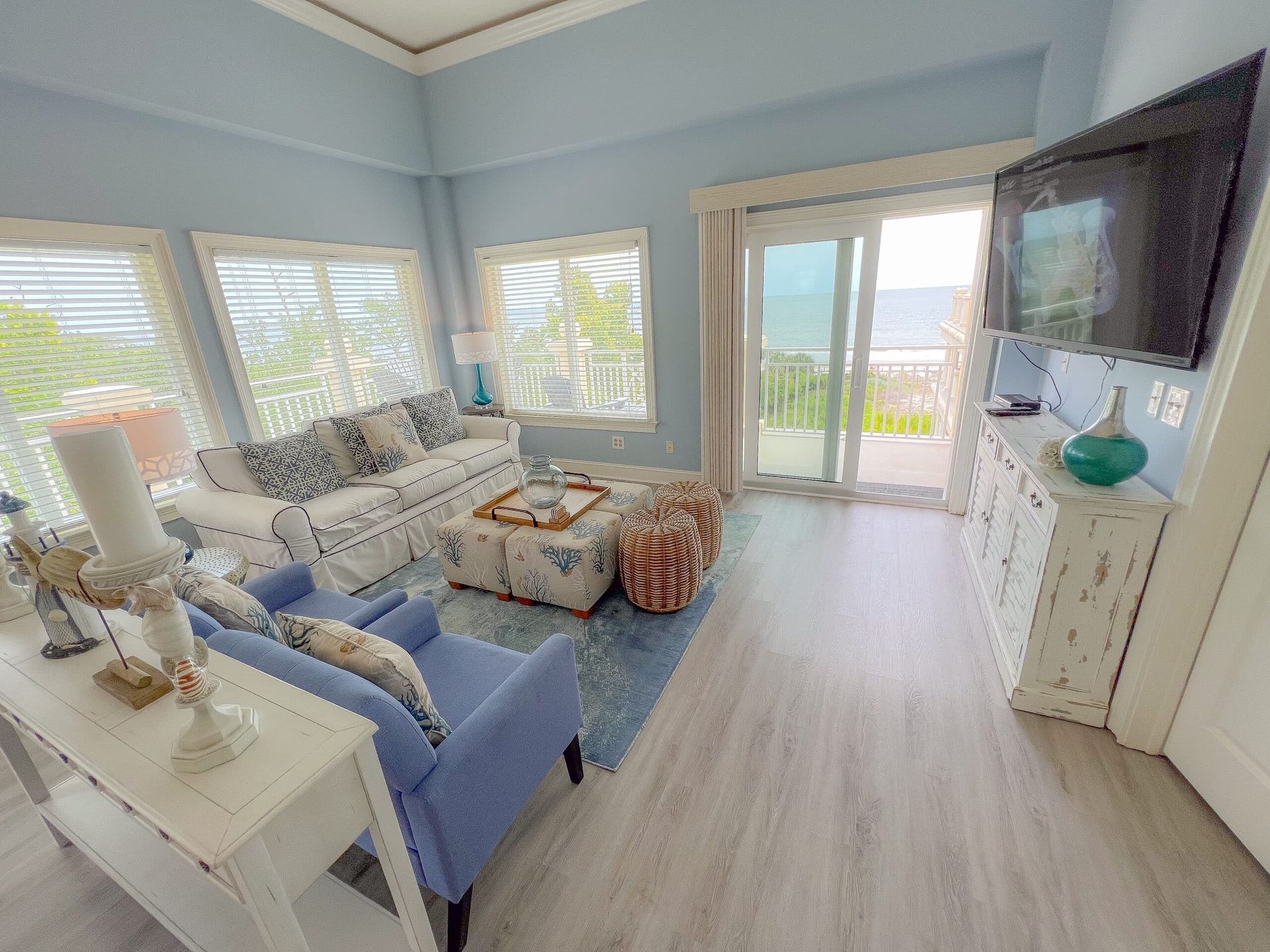 A living room with a couch , chairs , and a flat screen tv.