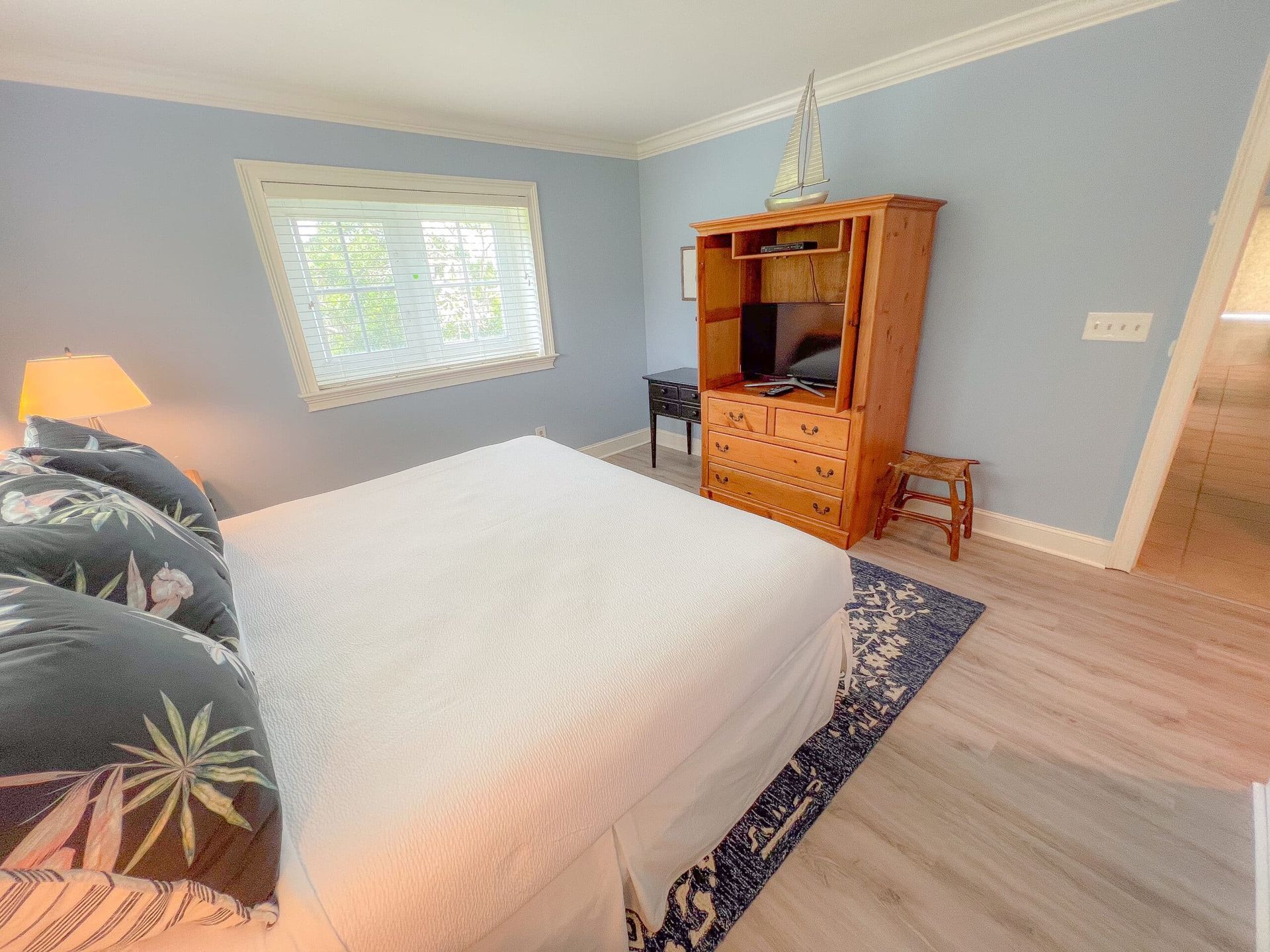 A bedroom with a king size bed , dresser , and television.