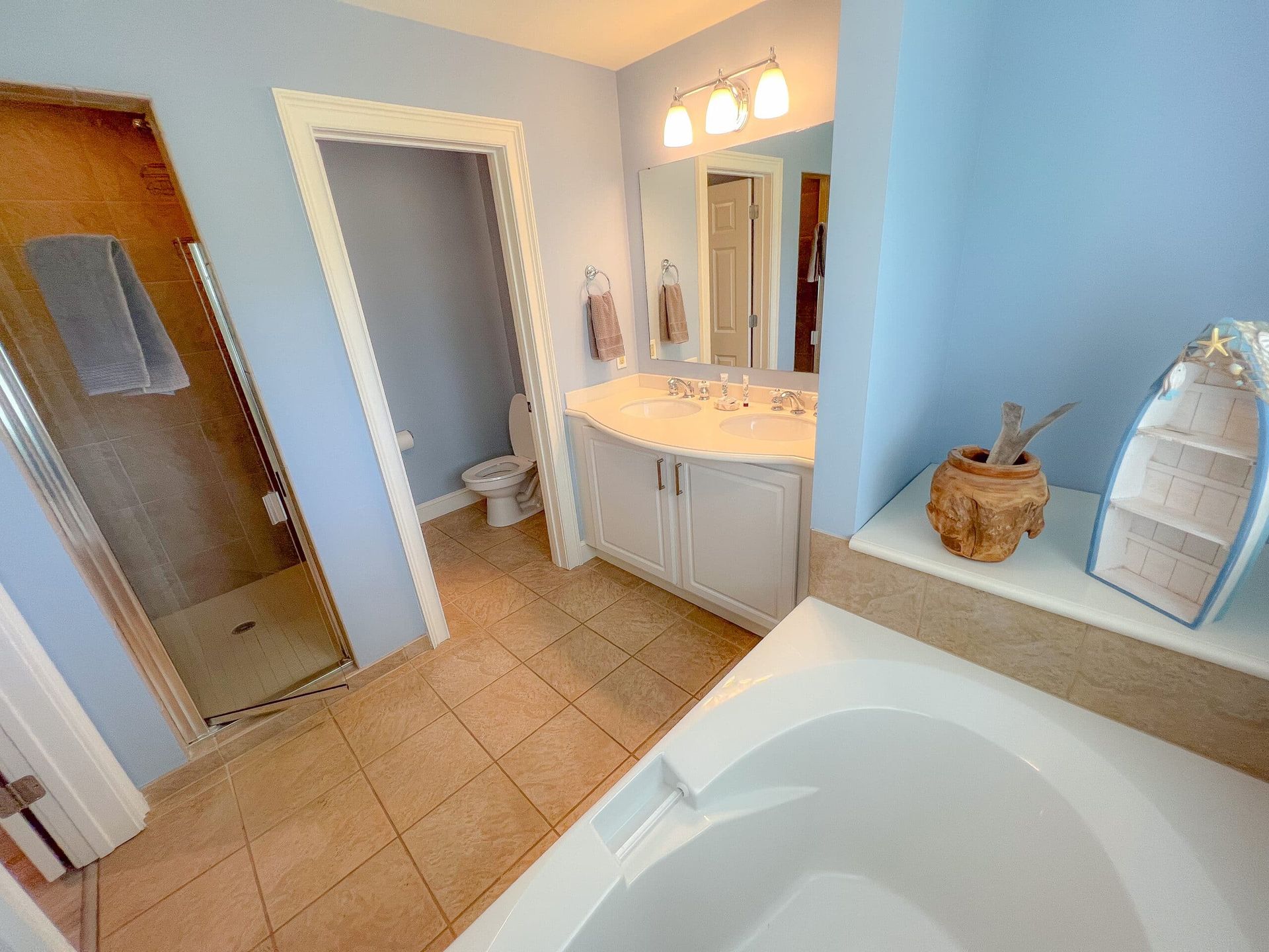 A bathroom with a tub , sink , toilet and shower