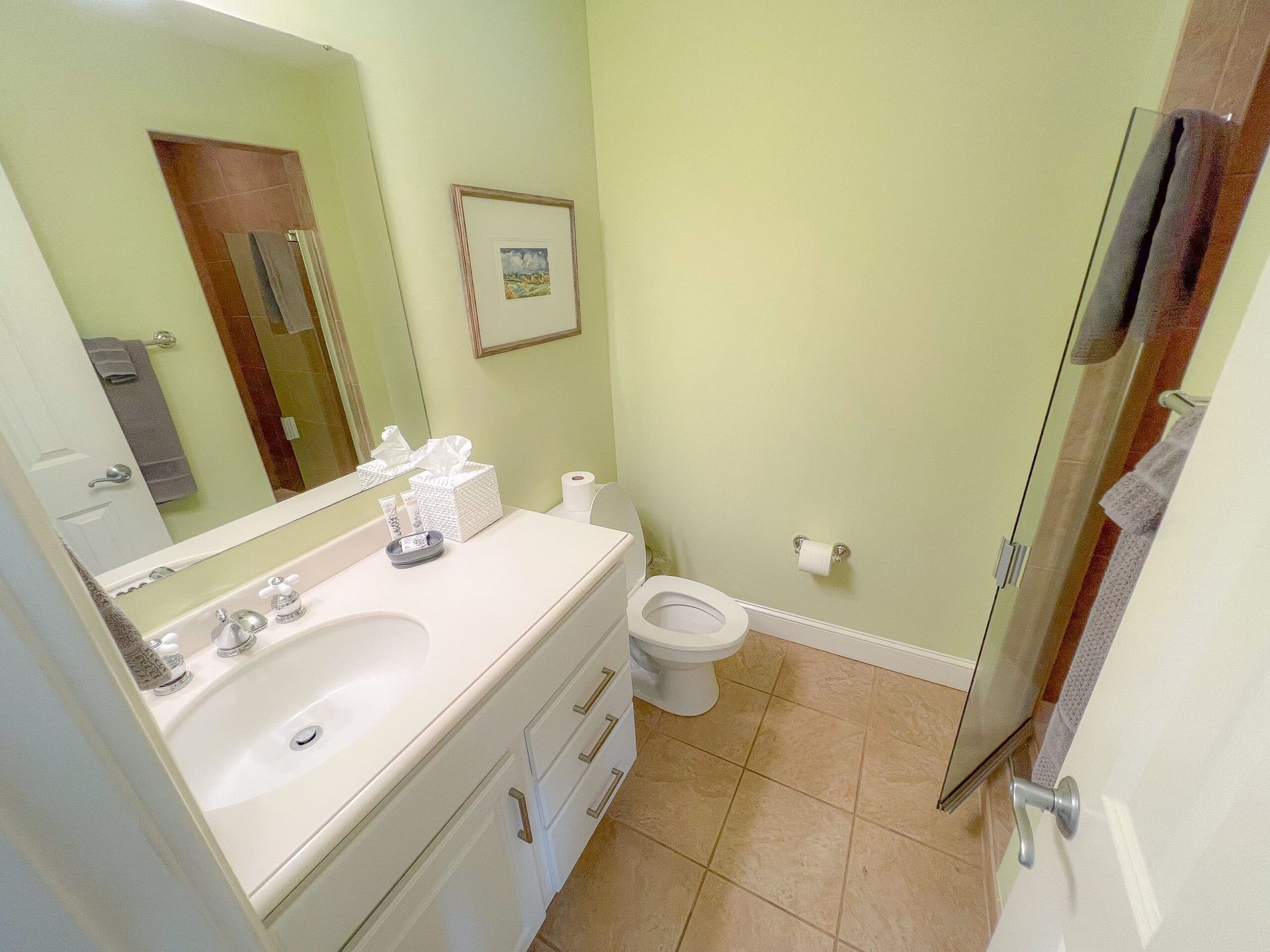A bathroom with a sink , toilet and mirror.