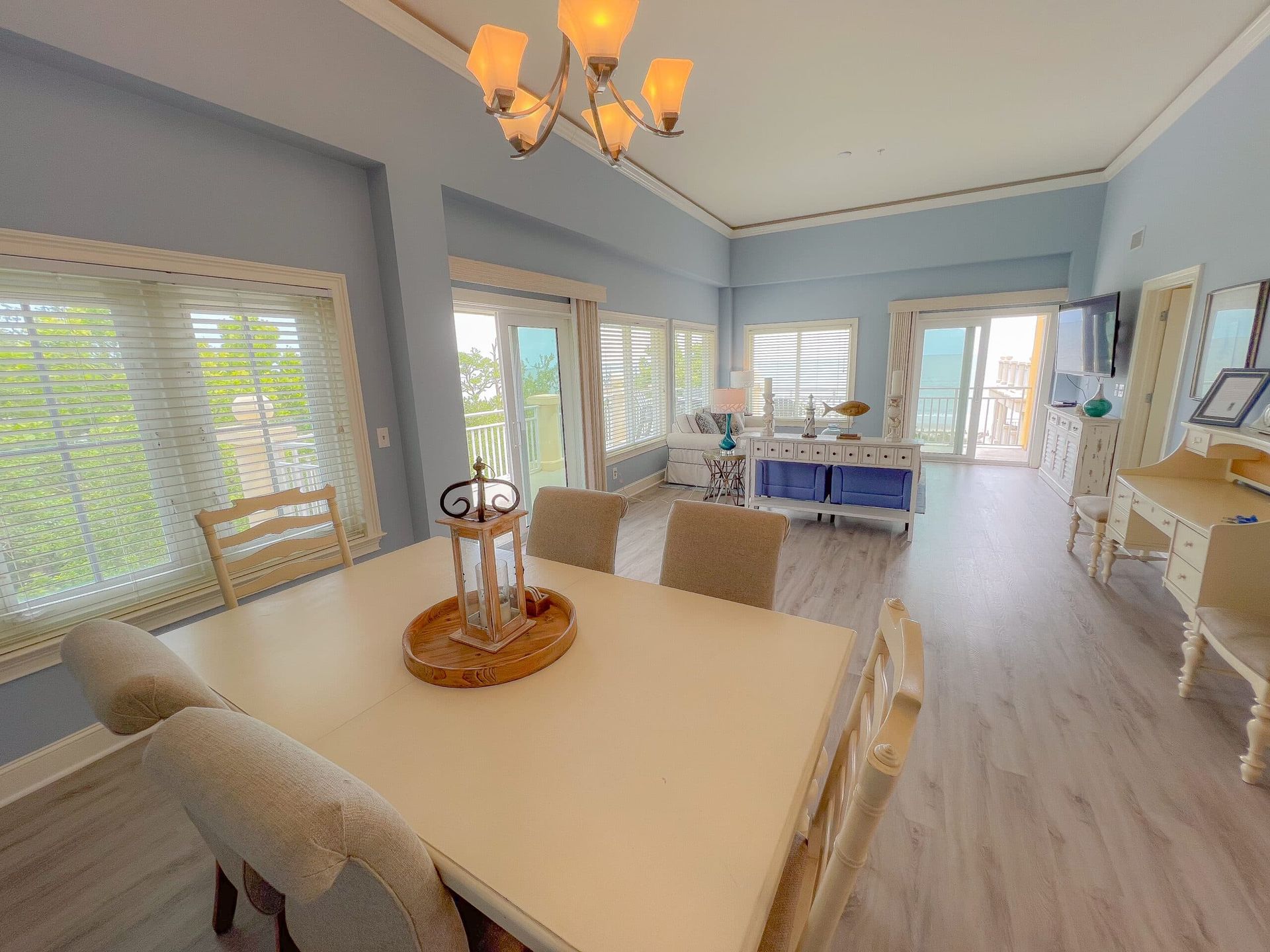 A living room with a dining table and chairs and a chandelier.