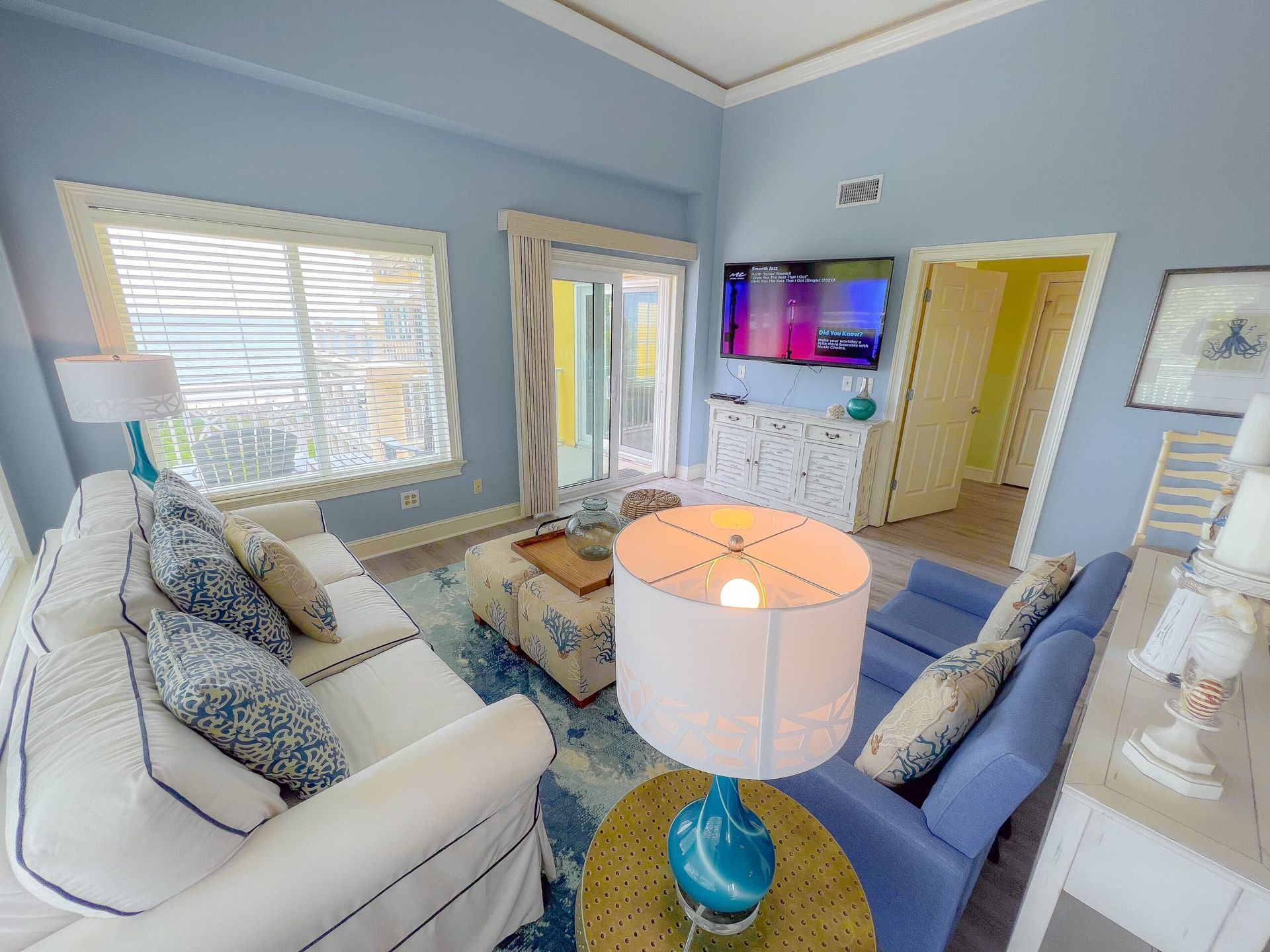 A living room with a couch , chair , lamp and television.