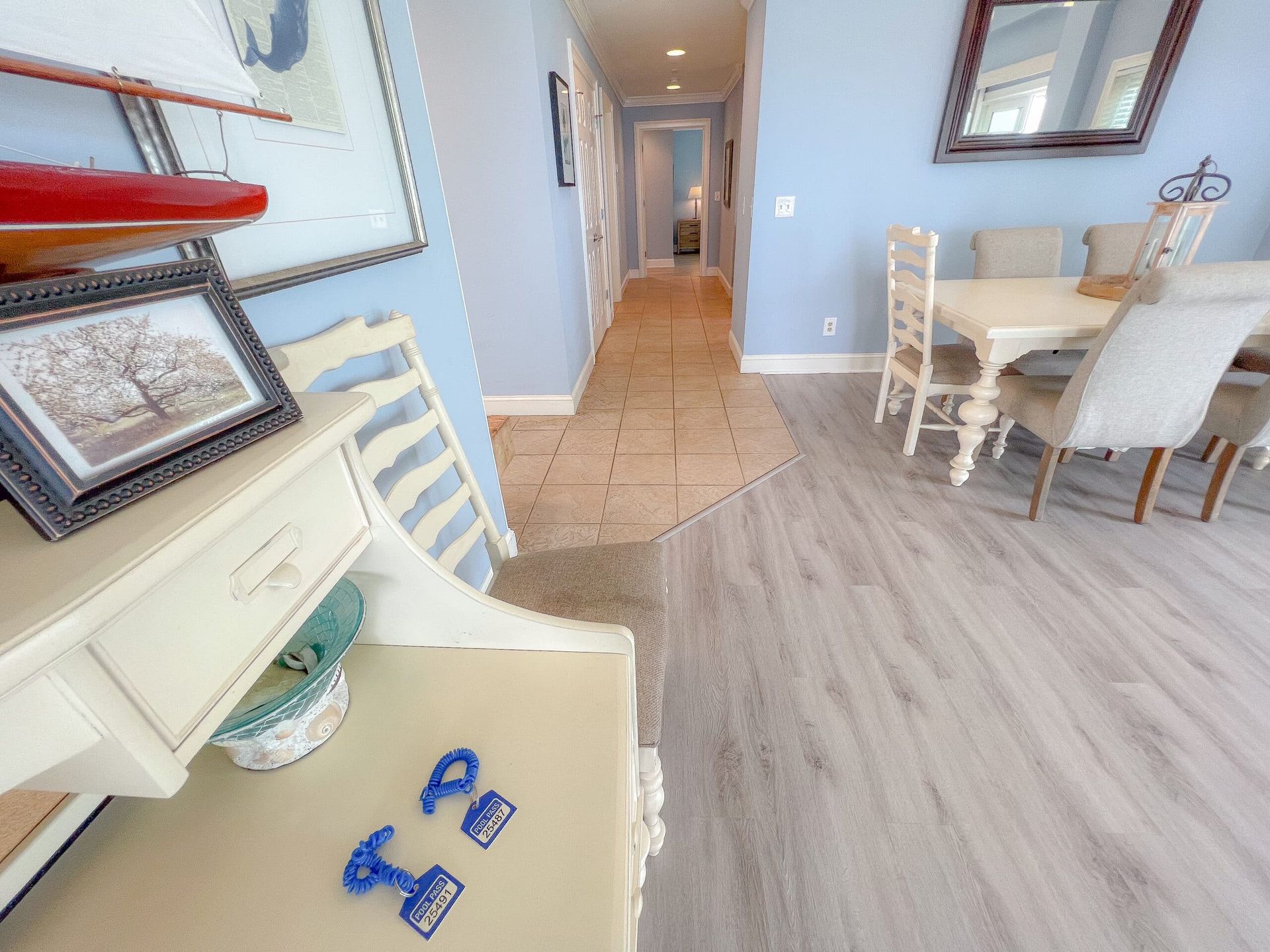 A living room with a table and chairs and a hallway