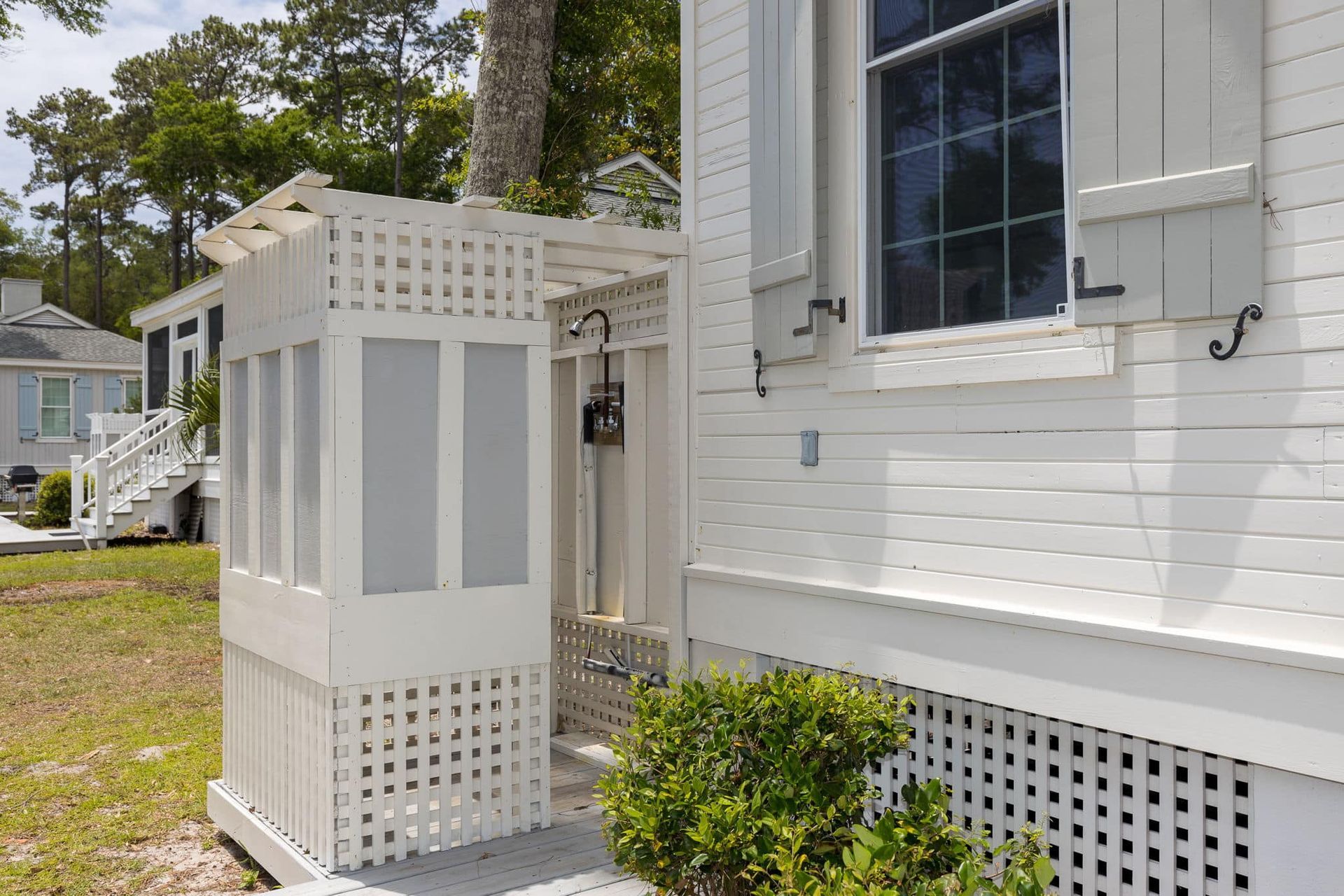 A white house with a walk in shower on the side of it.